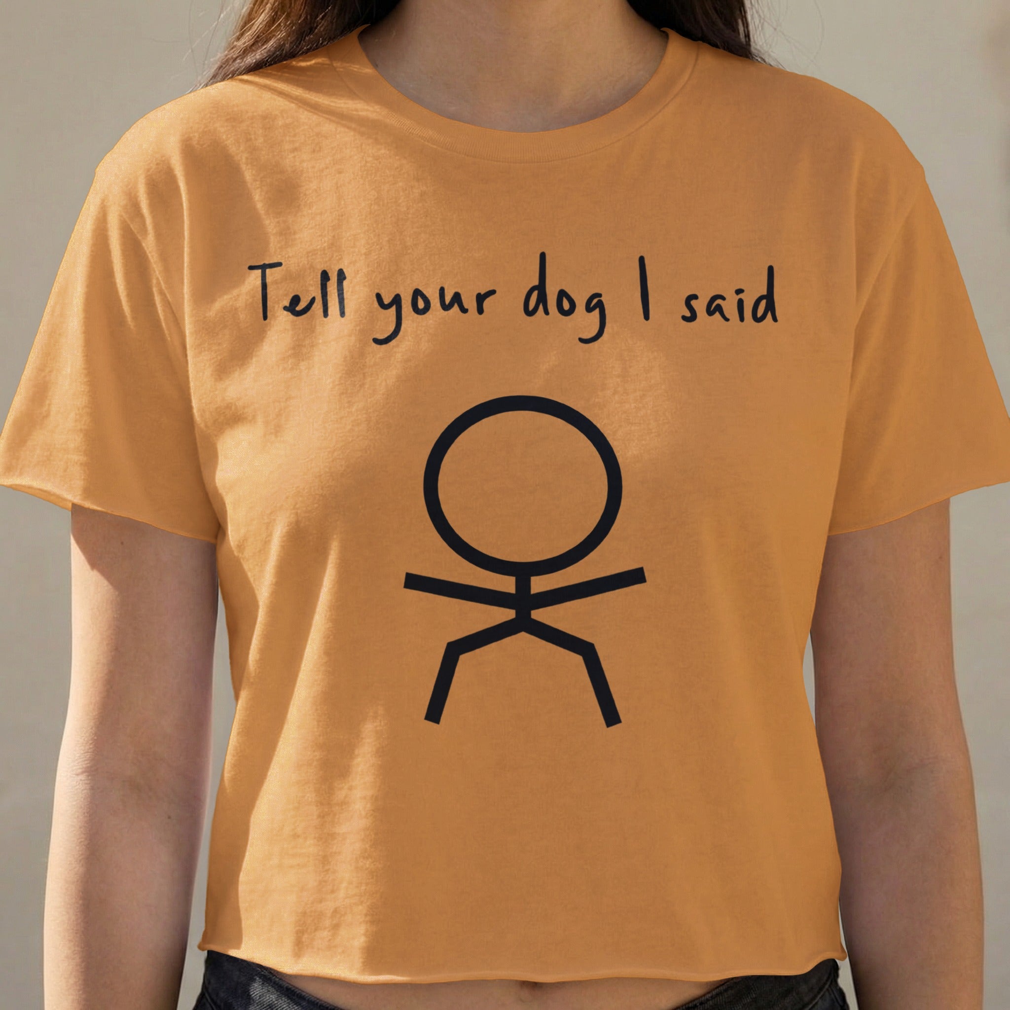 Orange cropped t-shirt with "Tell your dog I said" and stick figure.