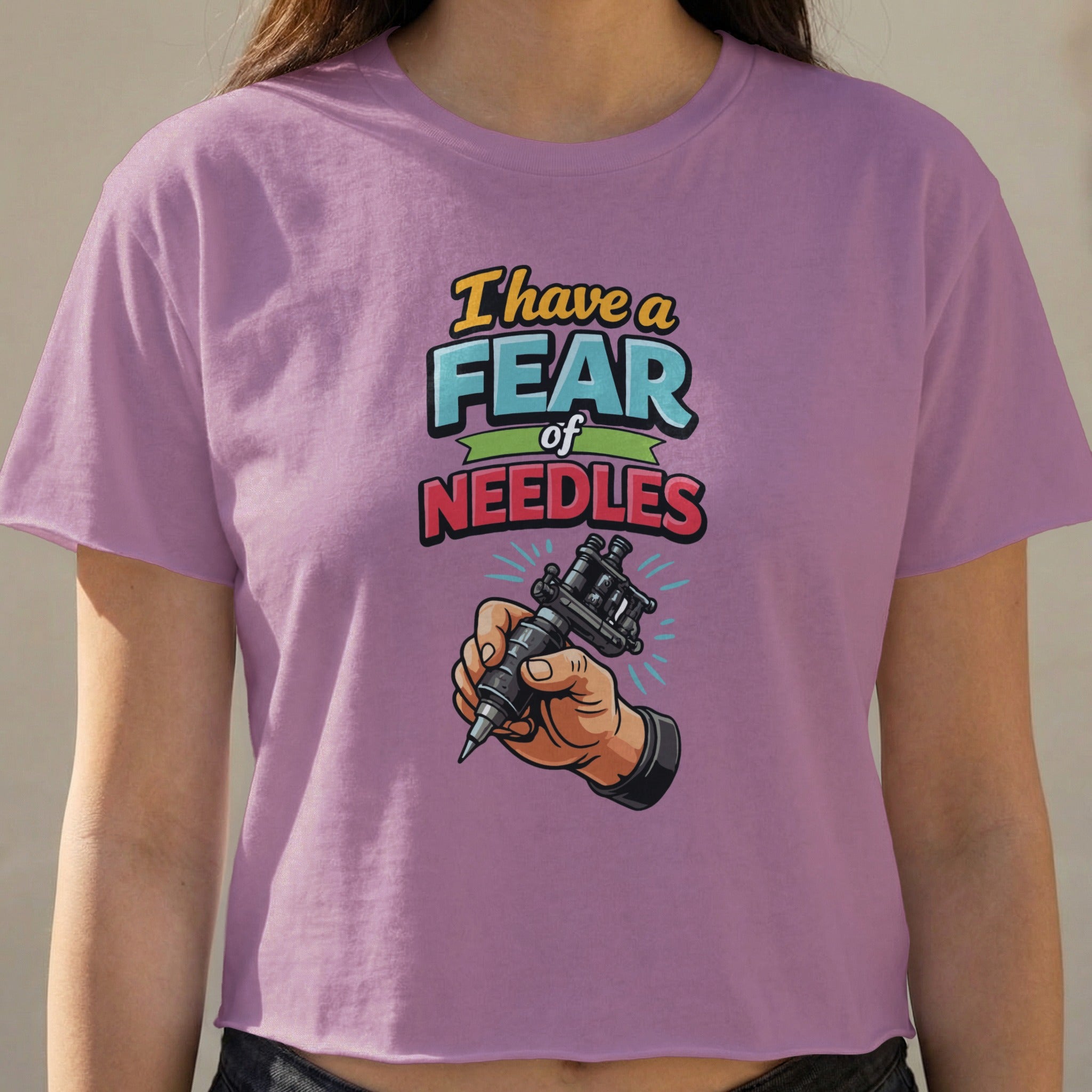 T-shirt with "I have a fear of needles" text and hand holding tattoo gun.
