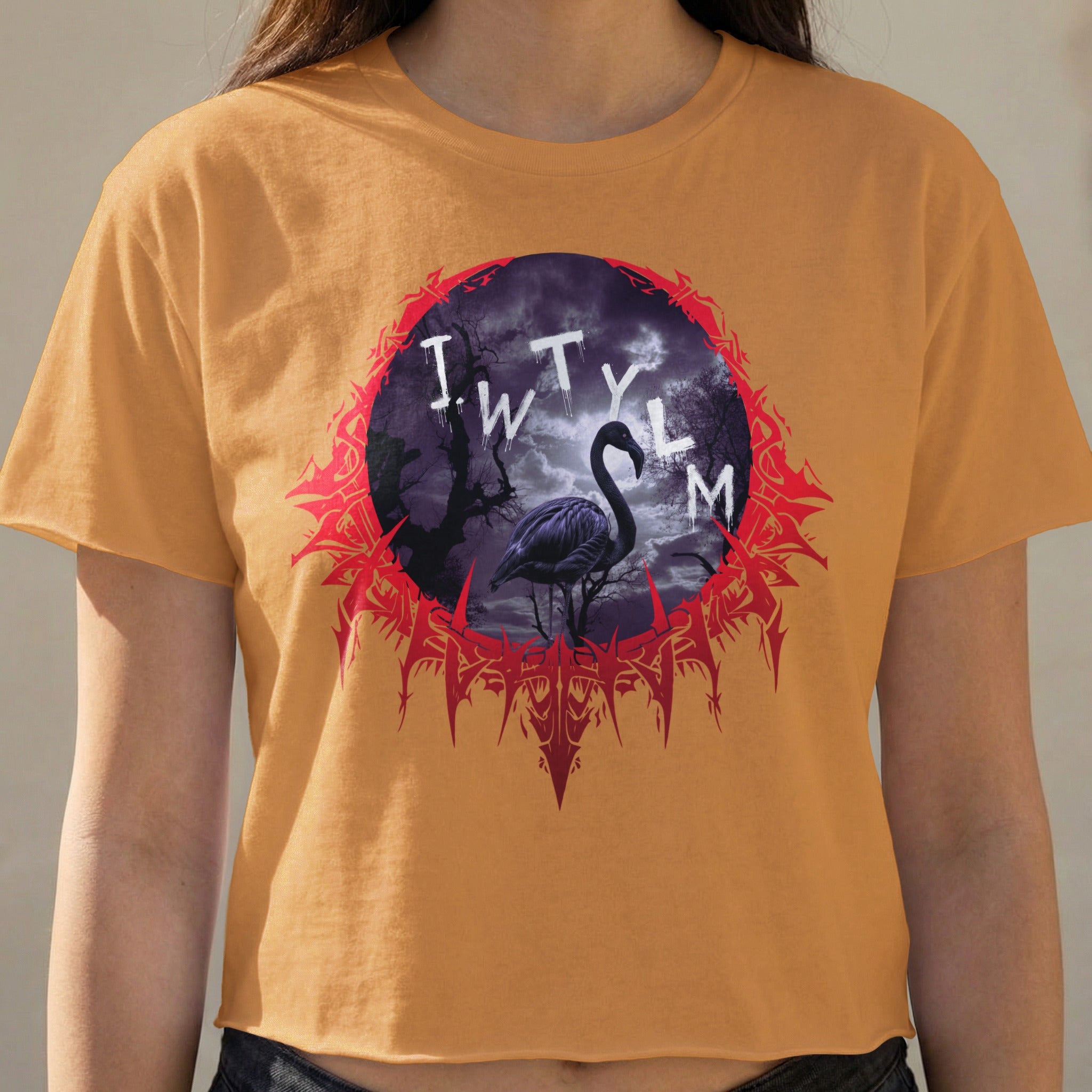 Orange crop top with "IWTYLM" text and a flamingo in a dark forest design.