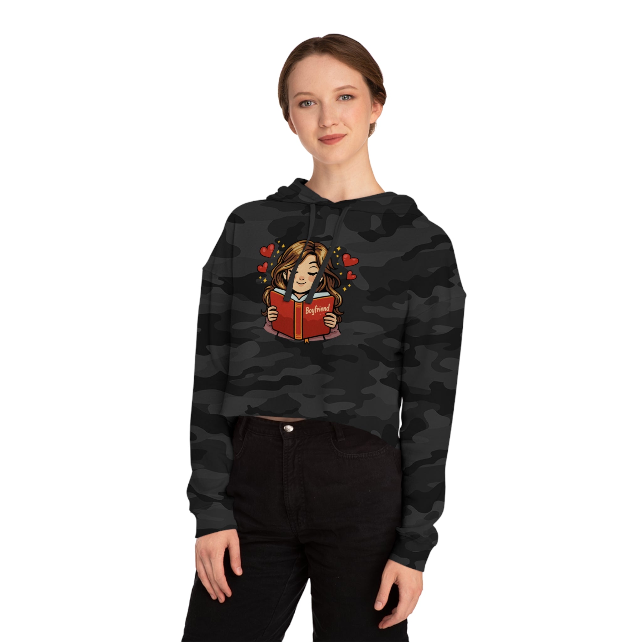 Woman wearing a black camouflage crop hoodie reading a book with "Boyfriend" on it.