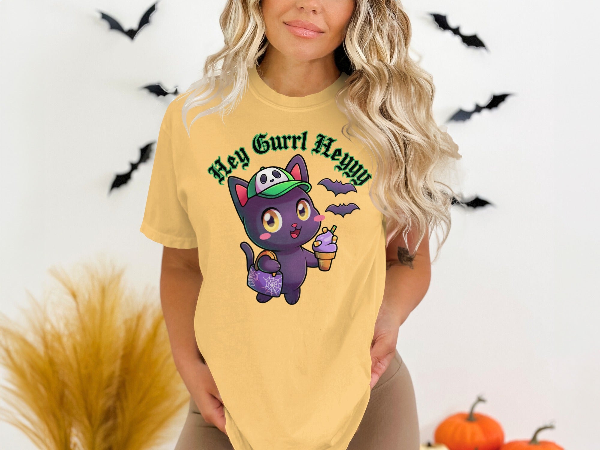 Yellow t-shirt with a cartoon black cat holding ice cream and wearing a hat.