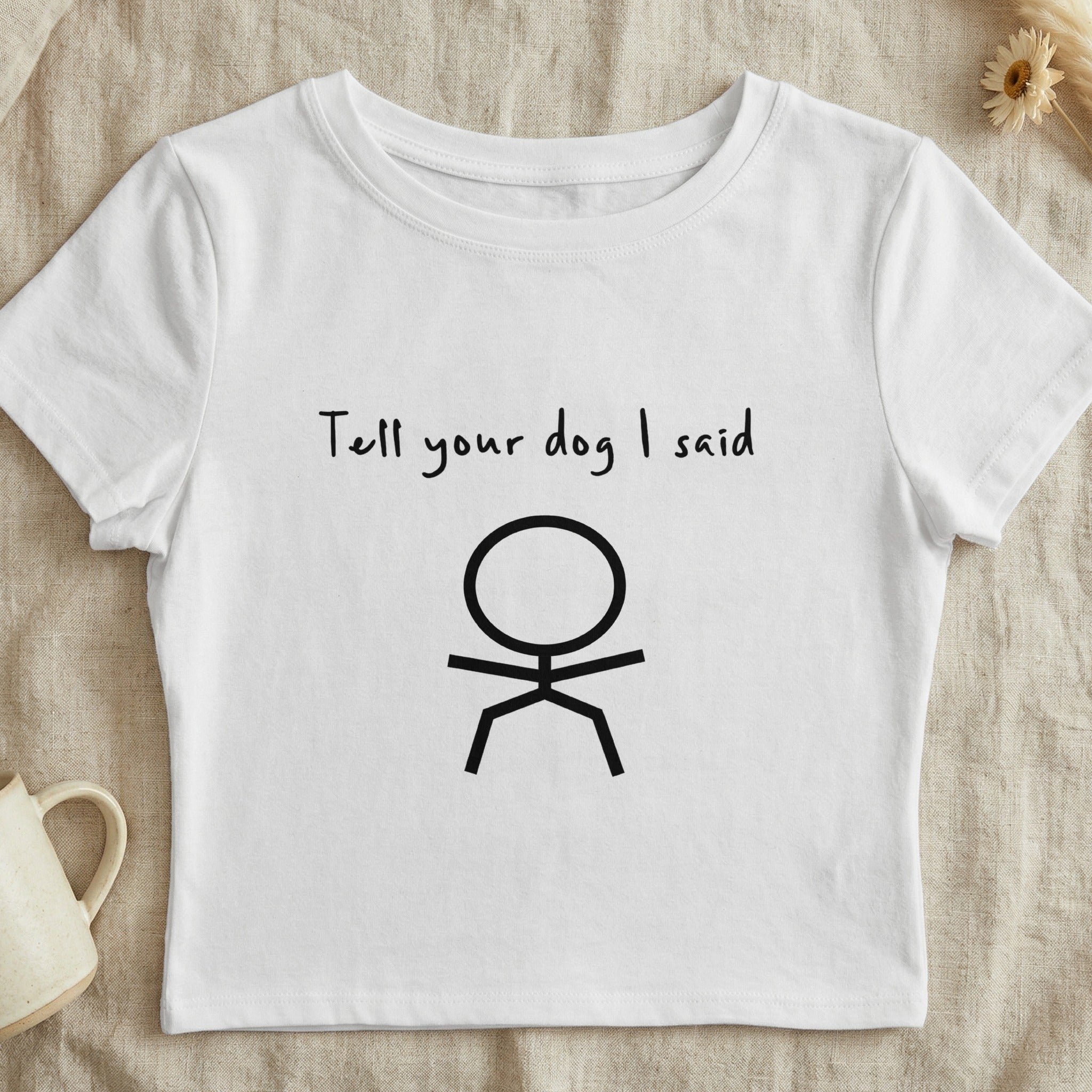 White t-shirt with "Tell your dog I said" and a stick figure drawing.