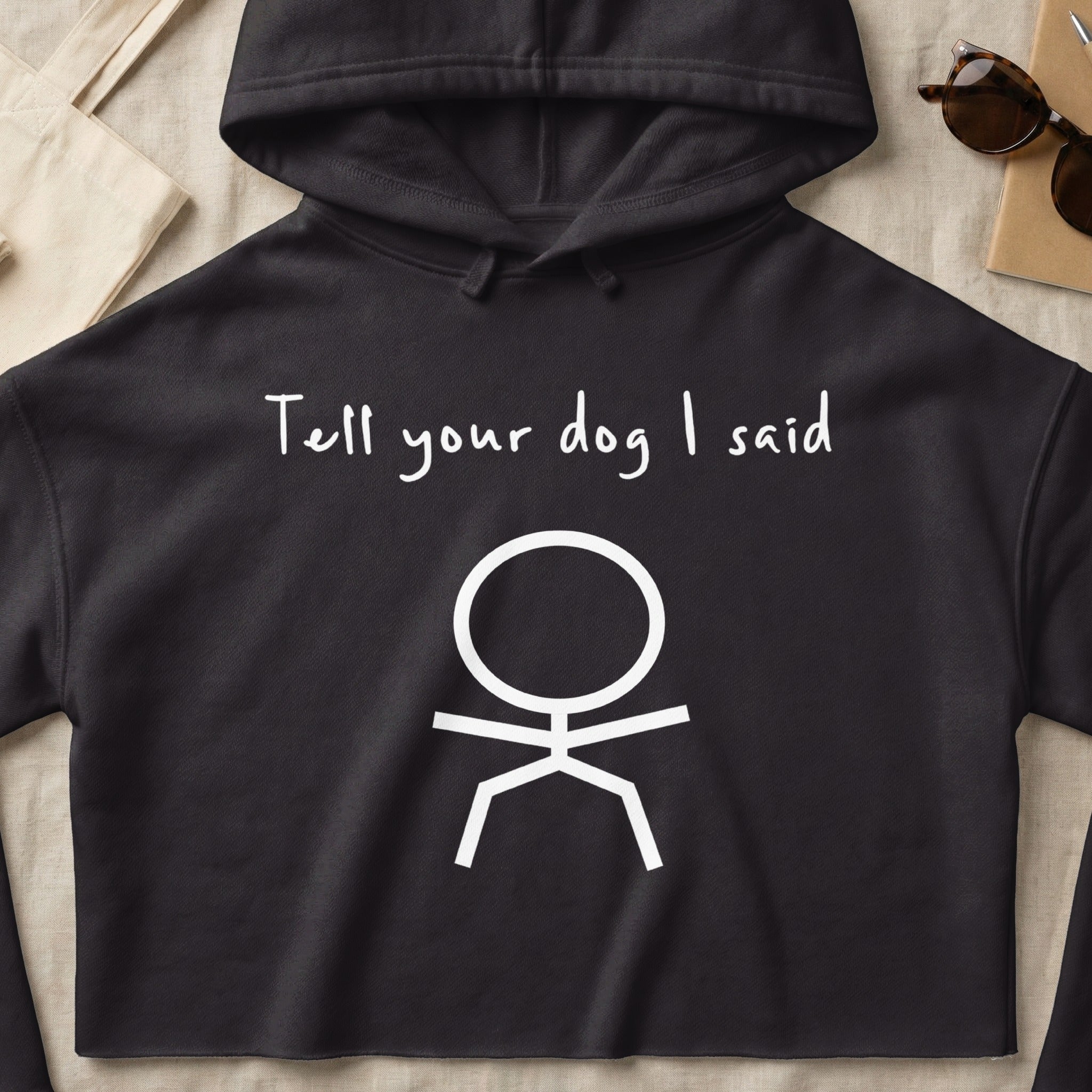 Black cropped hoodie with white text "Tell your dog I said" and a stick figure.