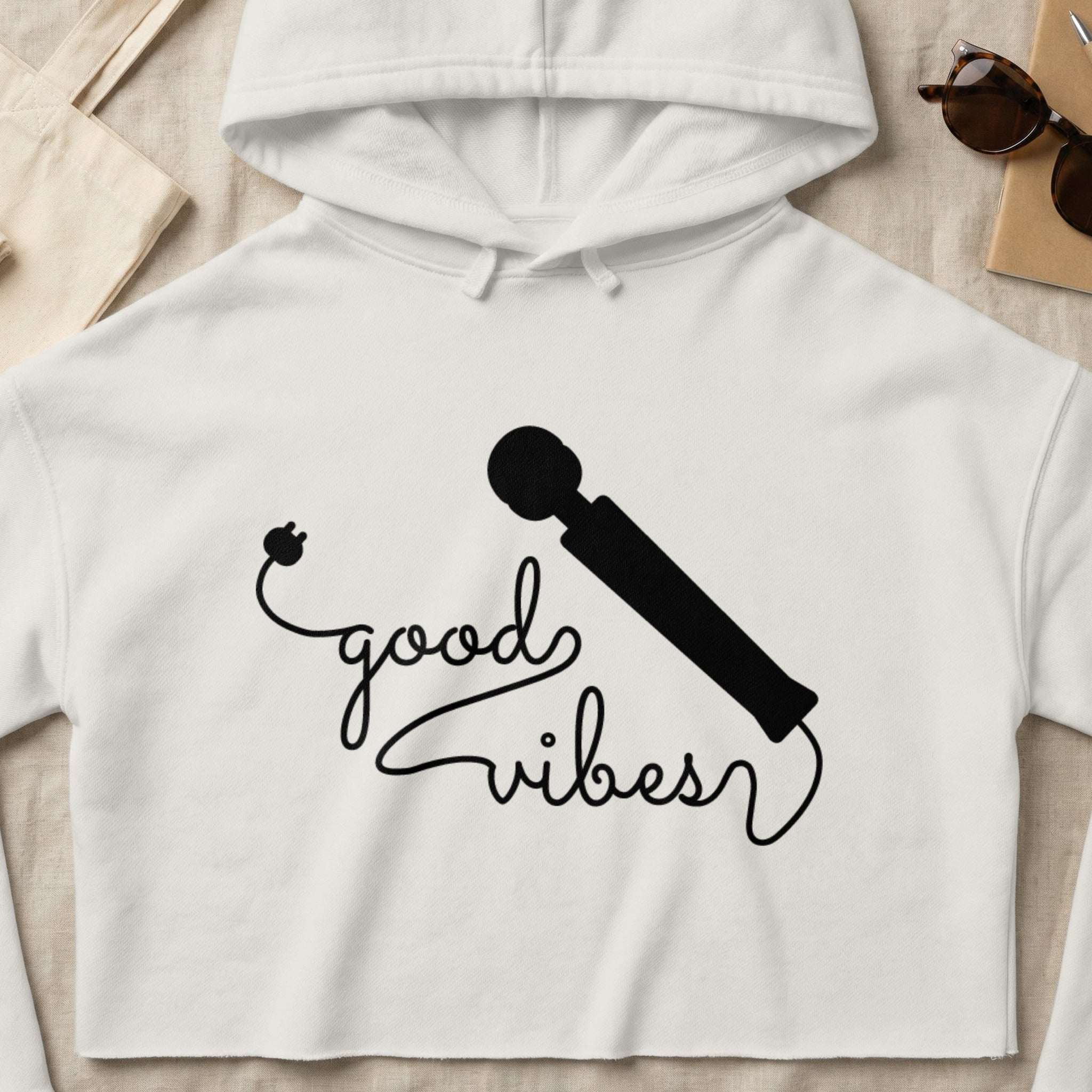 White cropped hoodie with "good vibes" text and a wand illustration.