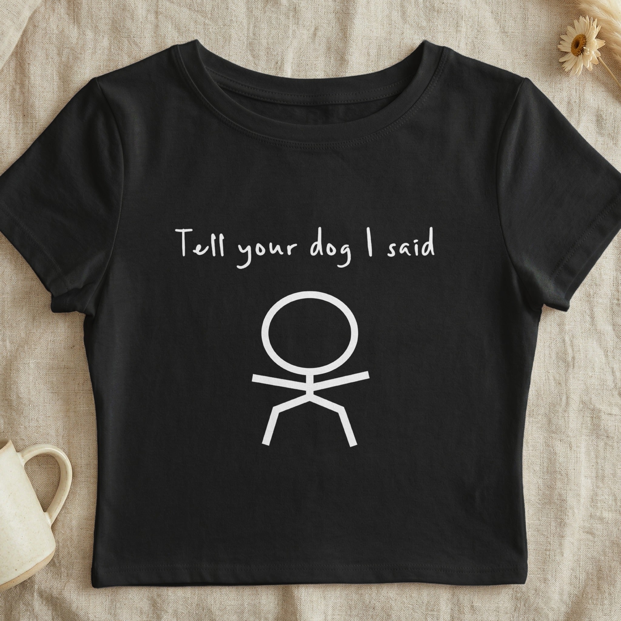 Black t-shirt with white stick figure and text "Tell your dog I said".