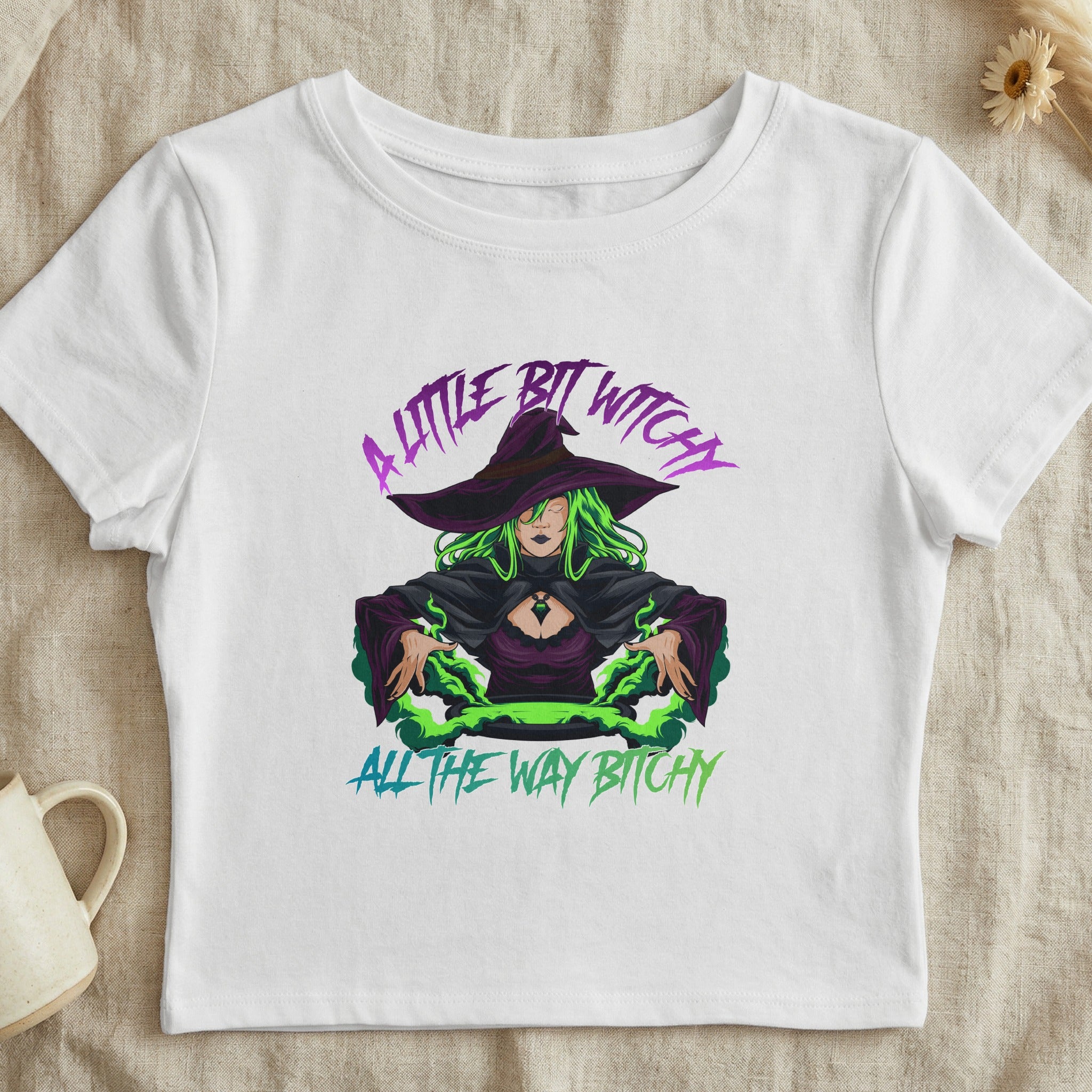 White cropped t-shirt with a witch illustration and text "A little bit witchy all the way bitchy."
