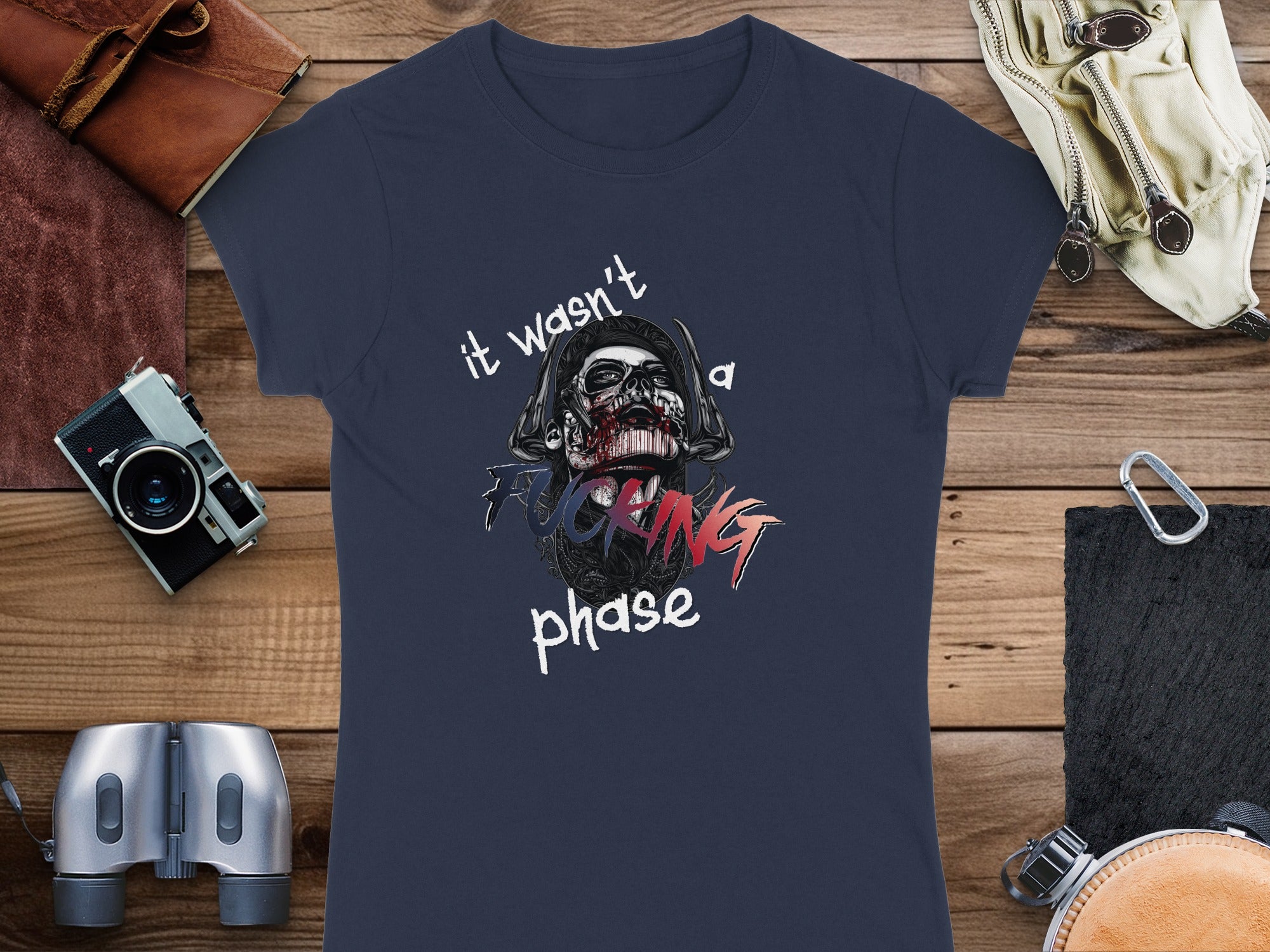 Dark t-shirt with graphic of a skull wearing a helmet and text "IT WASN'T A PHASE".