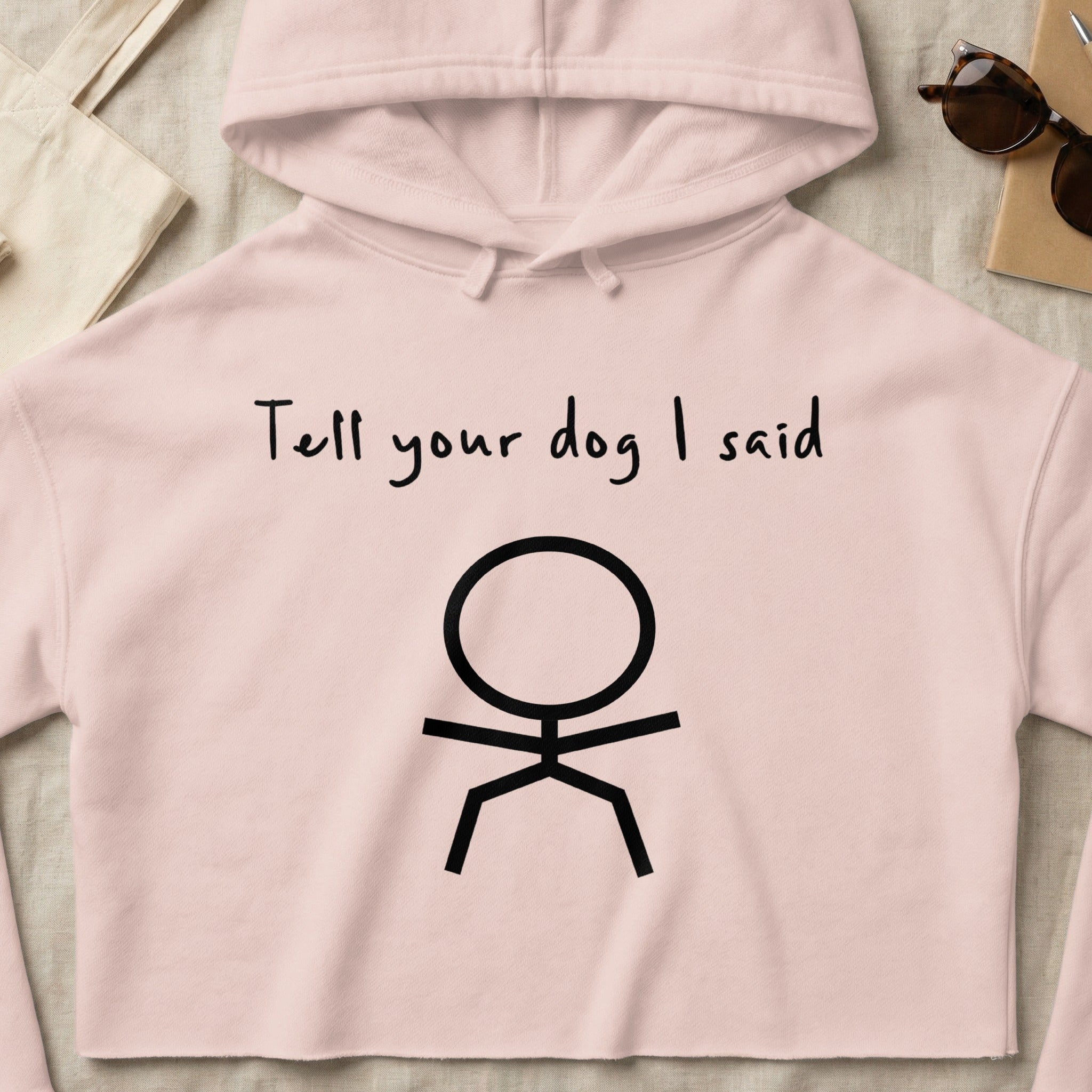 Pink cropped hoodie with stick figure and "Tell your dog I said" text.