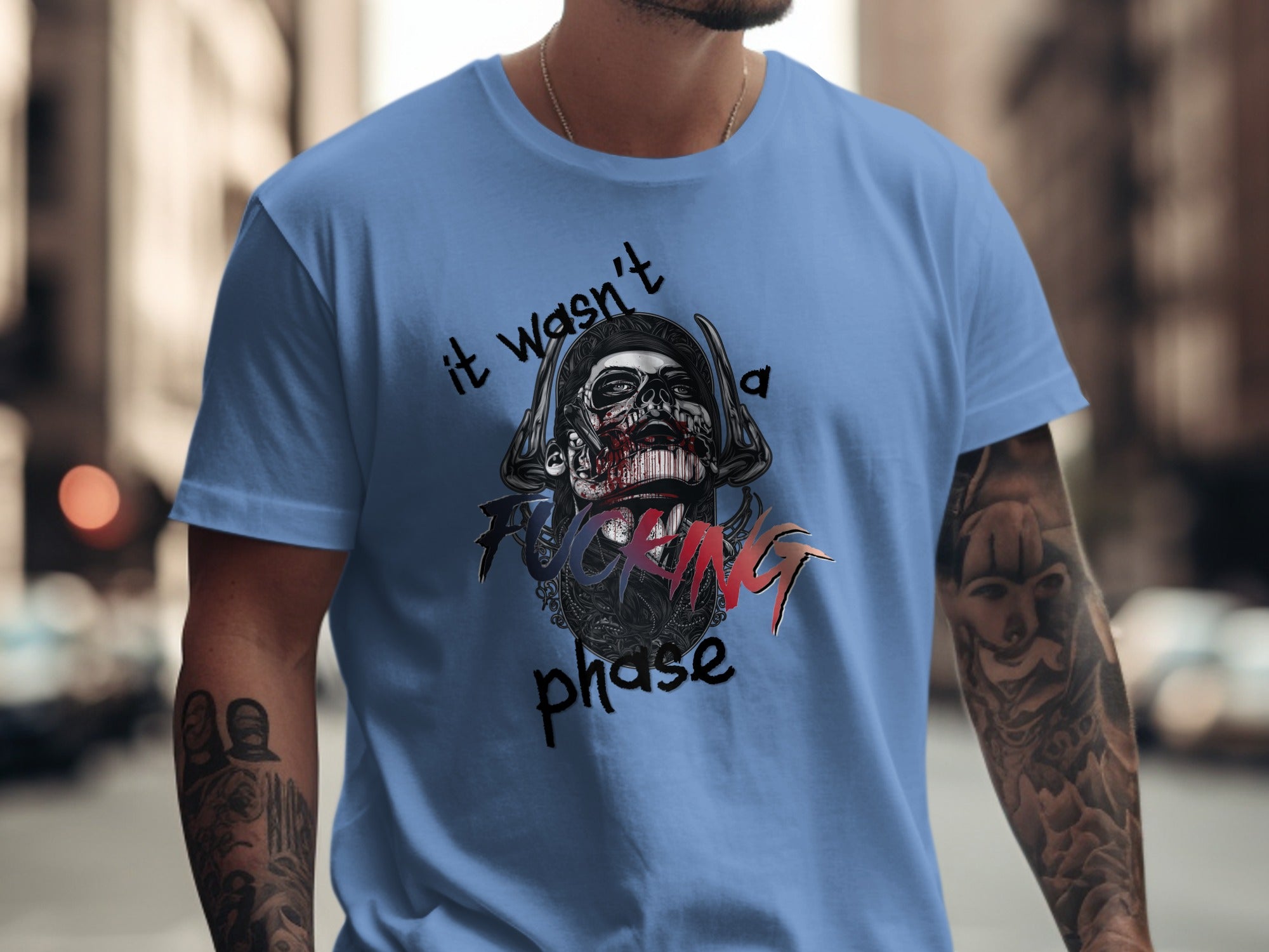 Light blue t-shirt with a skull graphic and "it wasn't a phase" text.