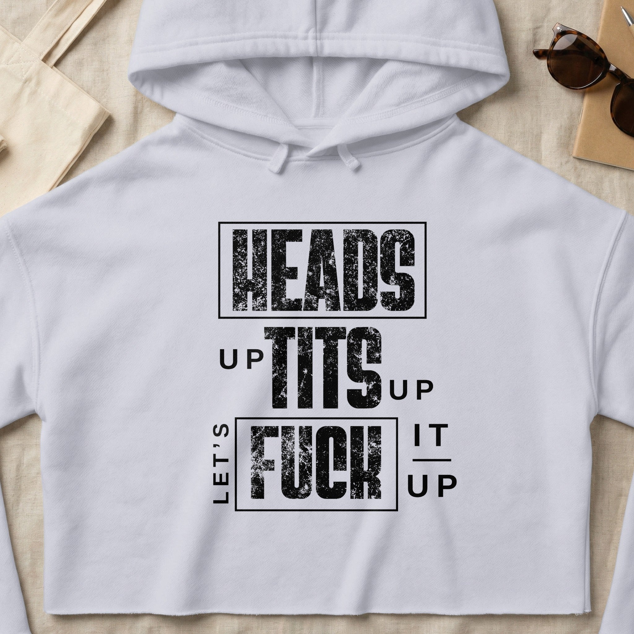 White cropped hoodie with "LET'S" and "HEADS UP TITS UP FUCK IT UP" text.