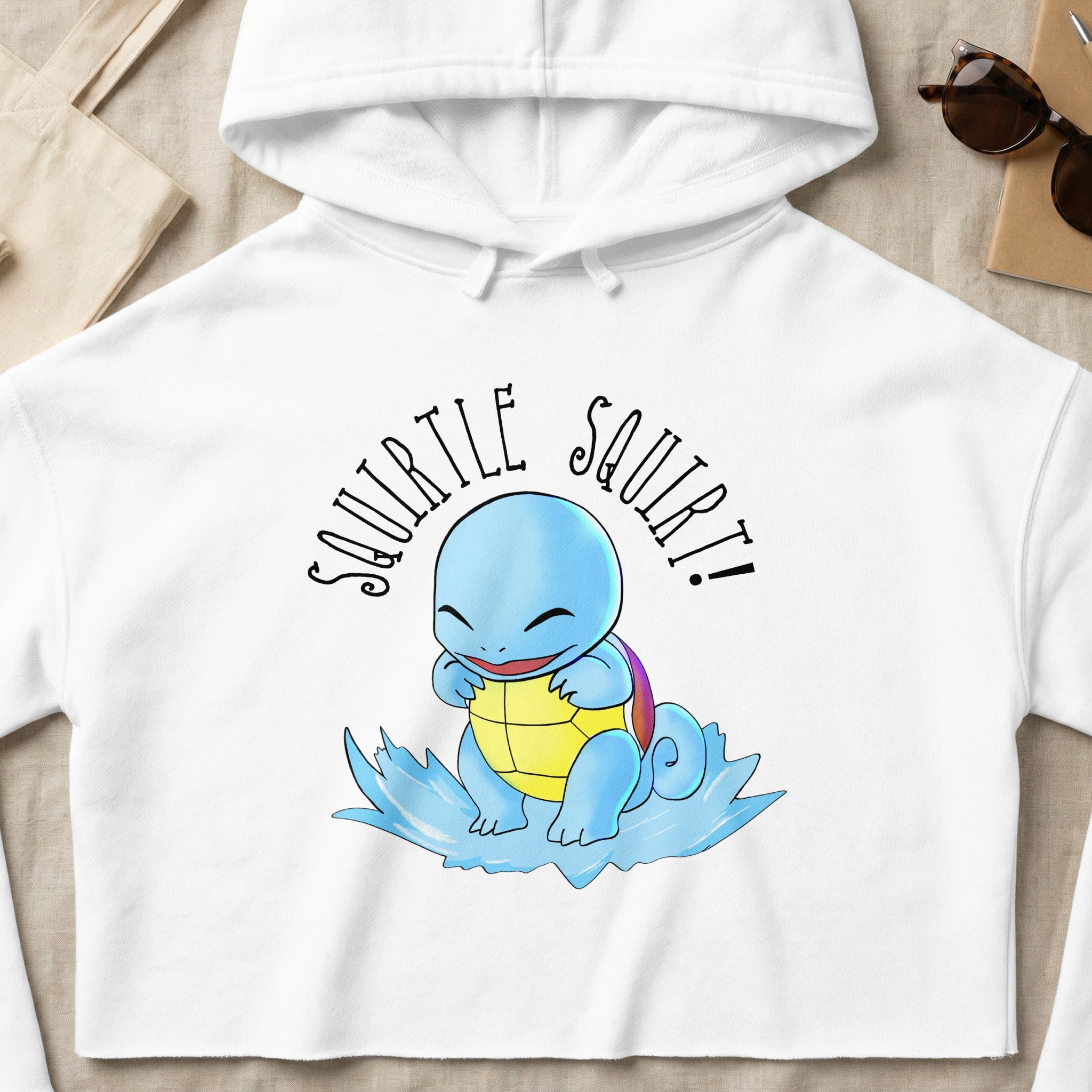 Squirtle wearing a hoodie, sitting on a blue water swirl.