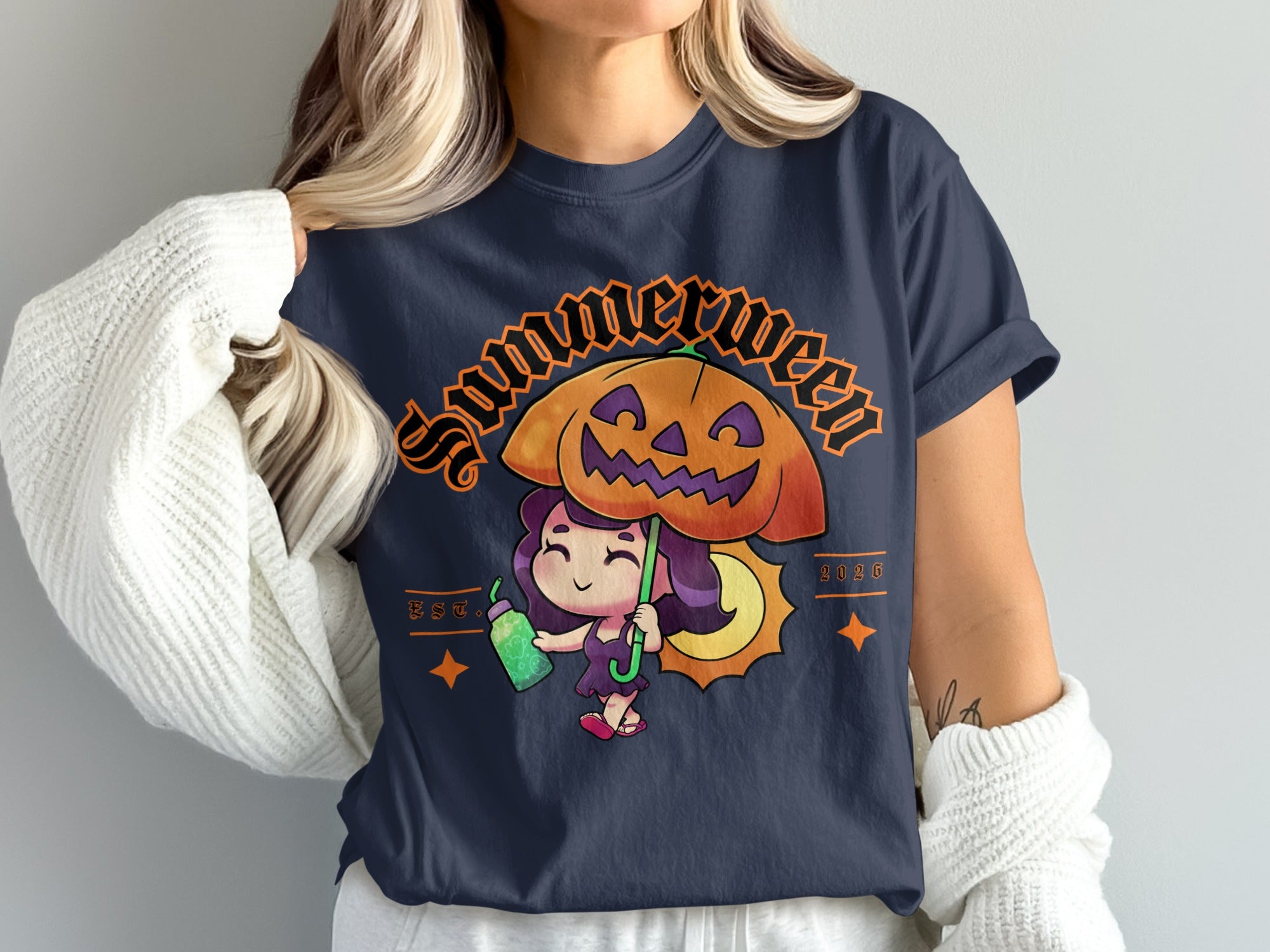 Dark t-shirt with "Summerween" graphic of a girl holding a pumpkin umbrella and a drink.