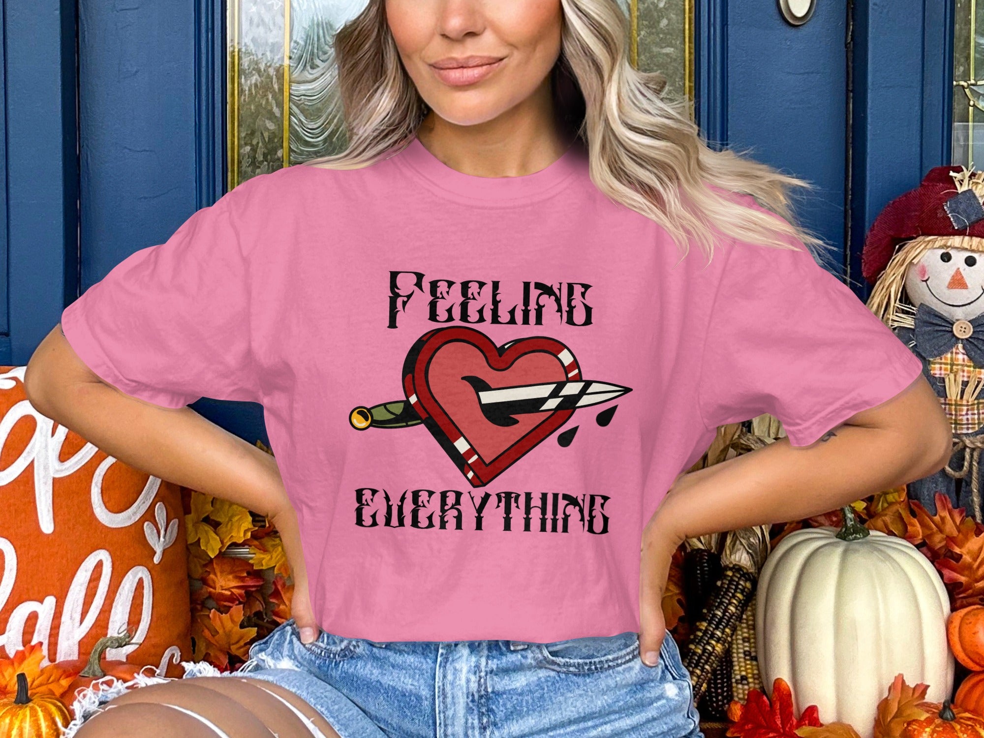 Pink t-shirt with "FEELING EVERYTHING" and a dagger through a heart design.
