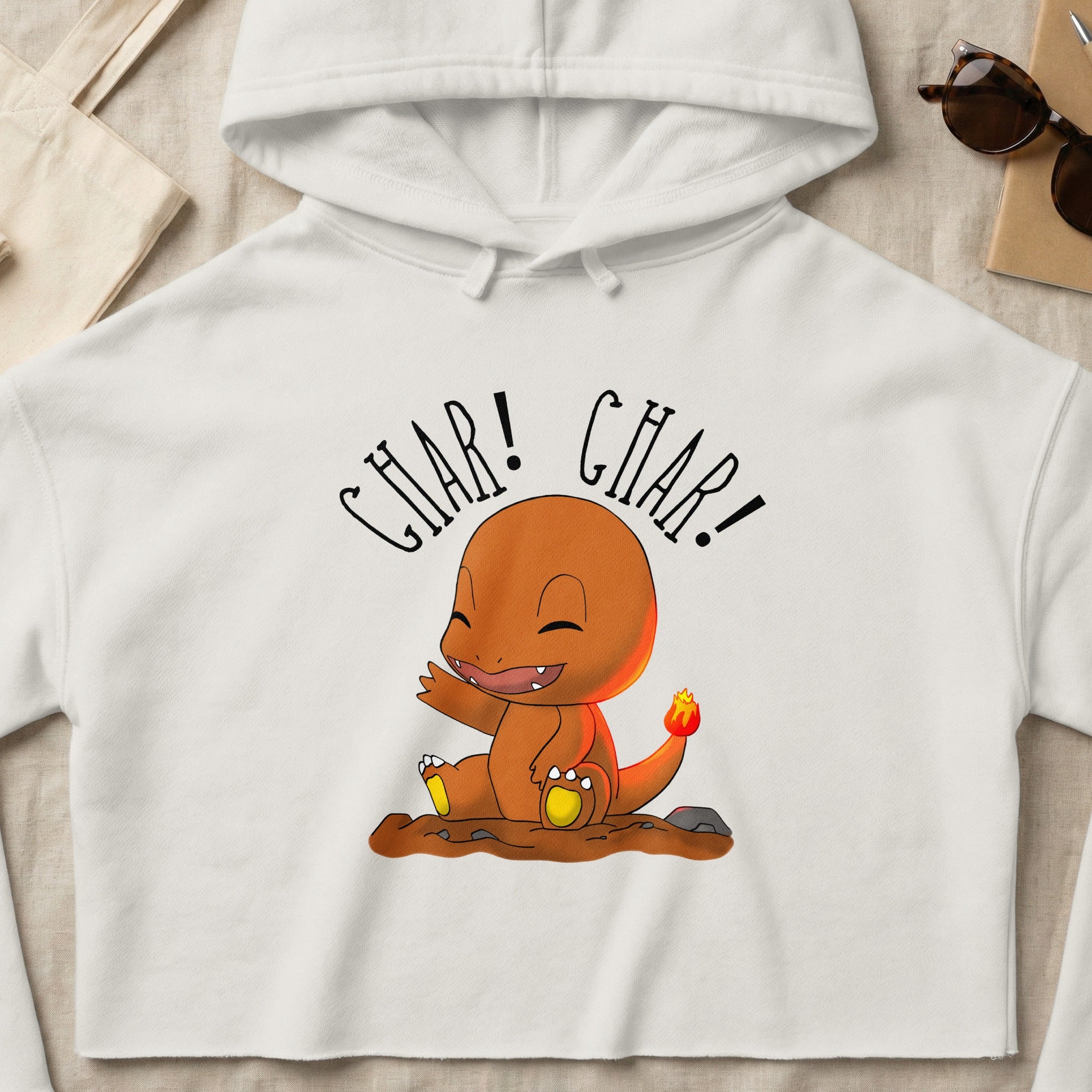 Charmander wearing a white cropped hoodie, sitting and smiling.