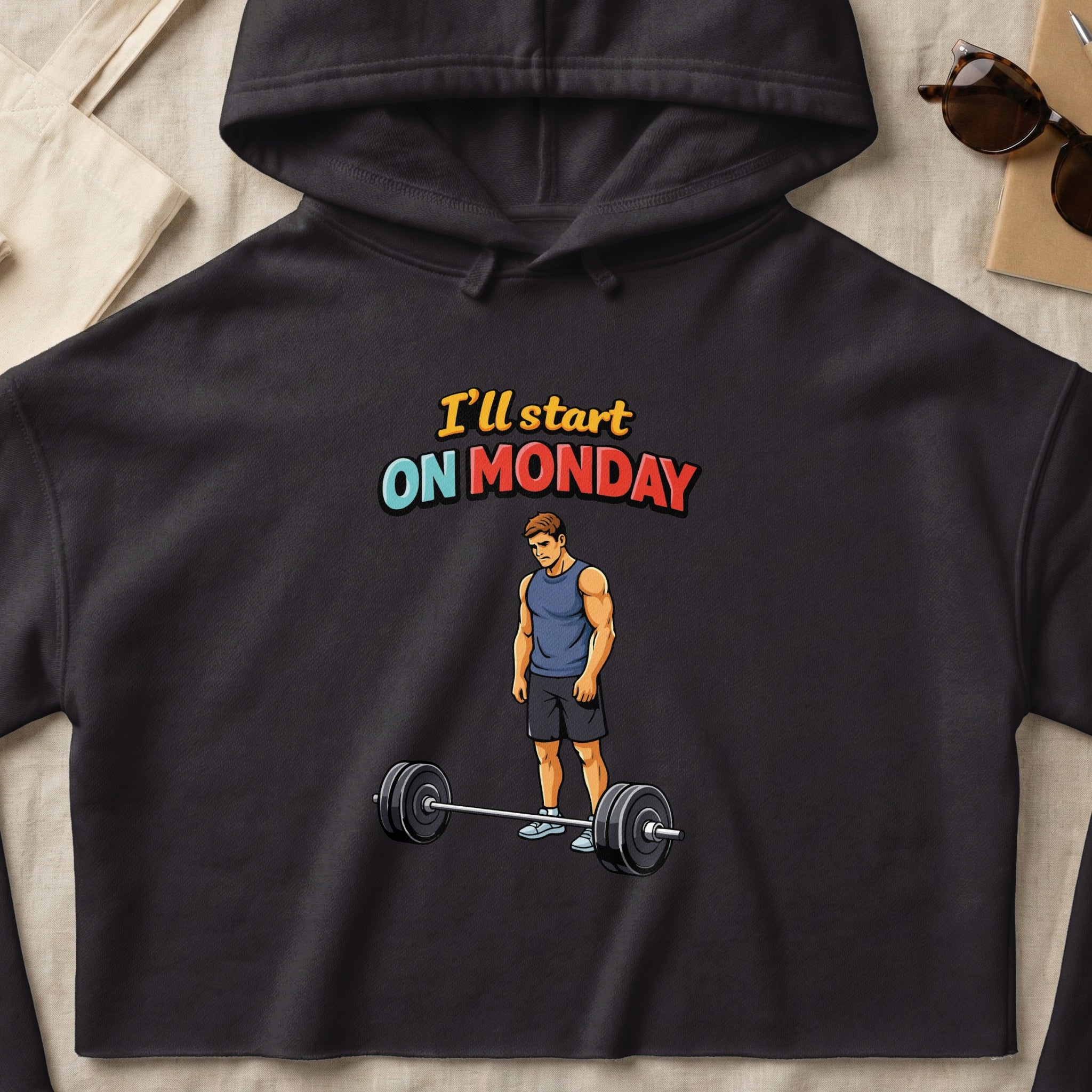 Black hoodie with "I'll start on Monday" text and illustration of a man with a barbell.