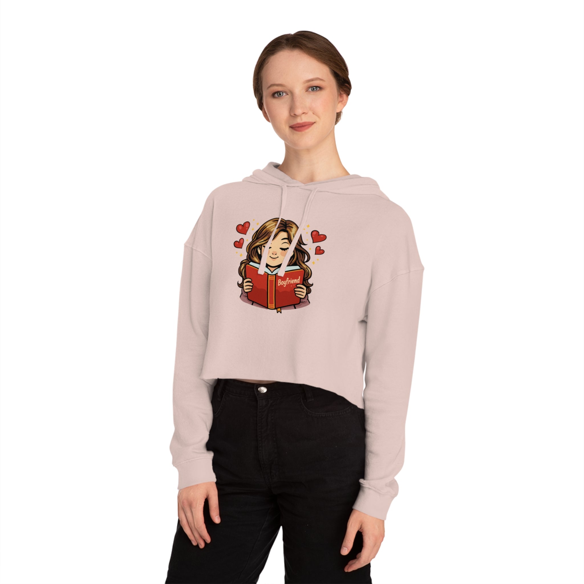 Woman wearing cropped hoodie reading a book titled "Boyfriend" with hearts.