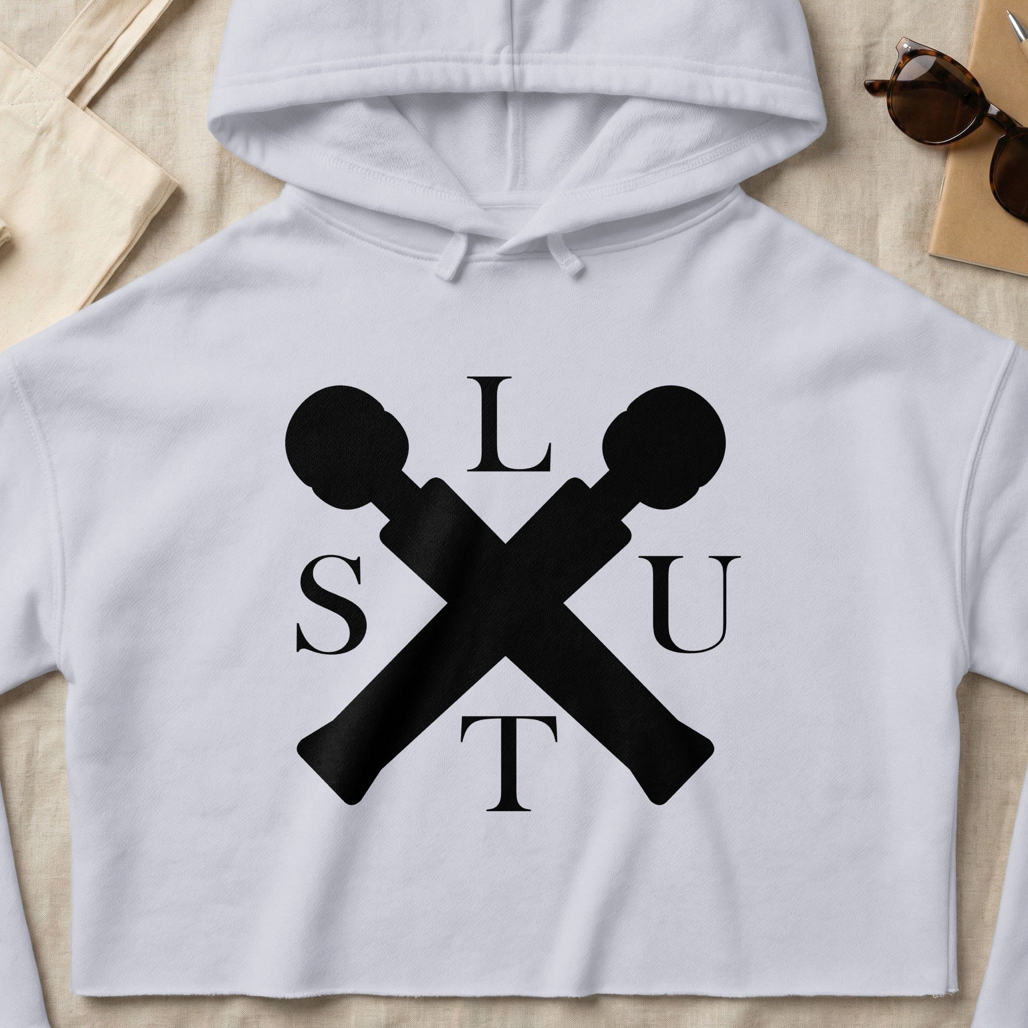 White cropped hoodie with "SLUT" text and crossed microphones graphic.