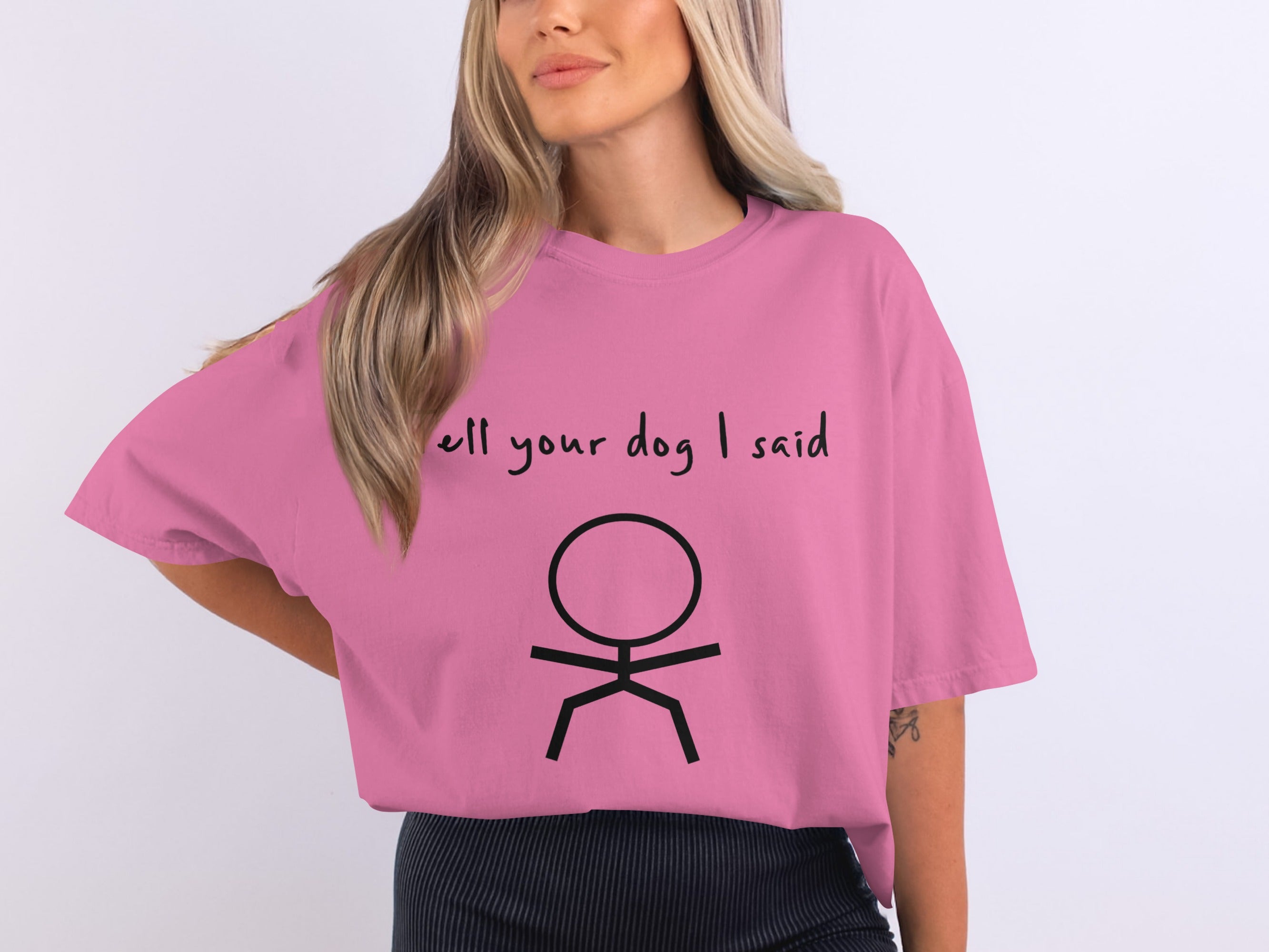 Pink t-shirt with "tell your dog I said" and stick figure graphic.