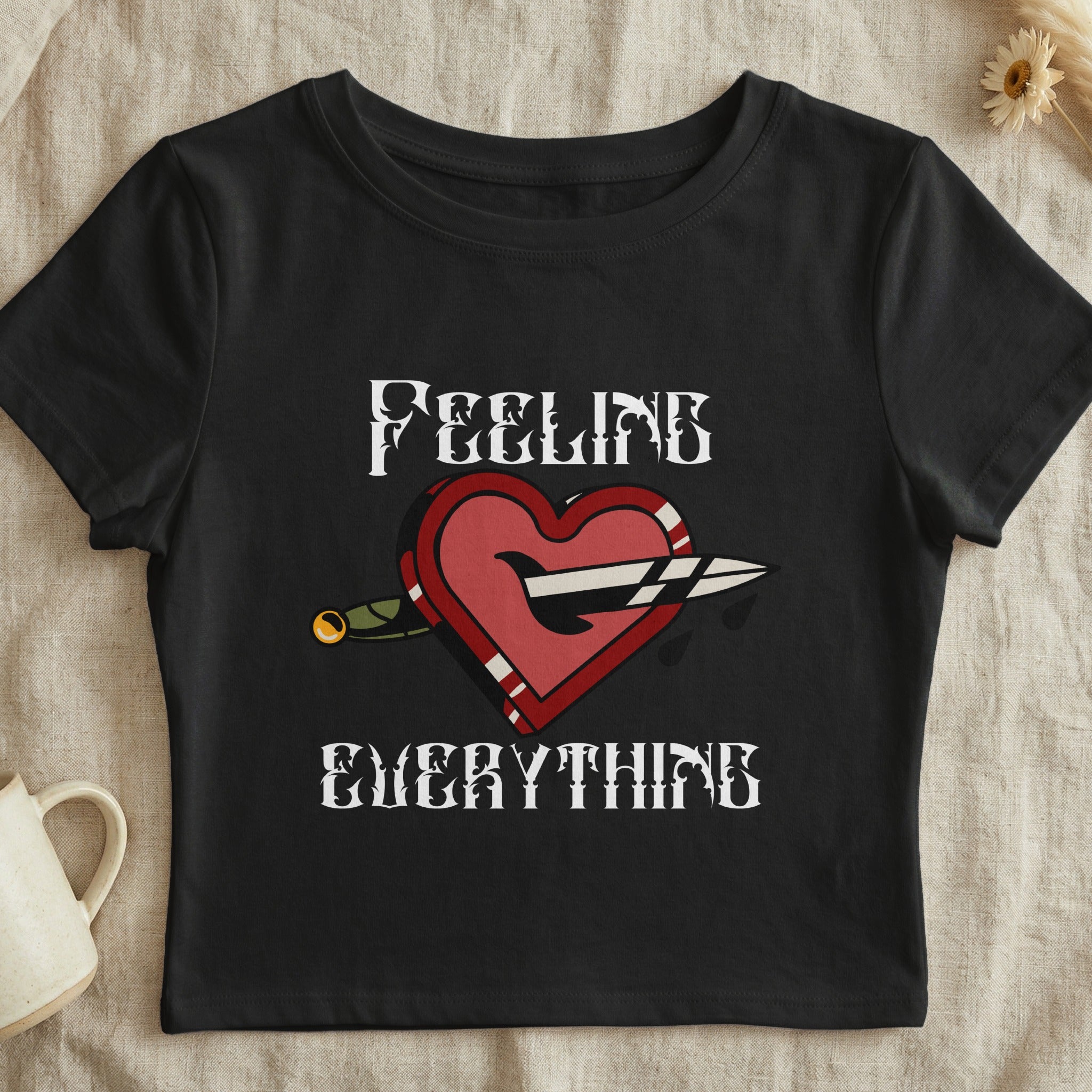Black t-shirt with heart, dagger, and "FEELING EVERYTHING" text.