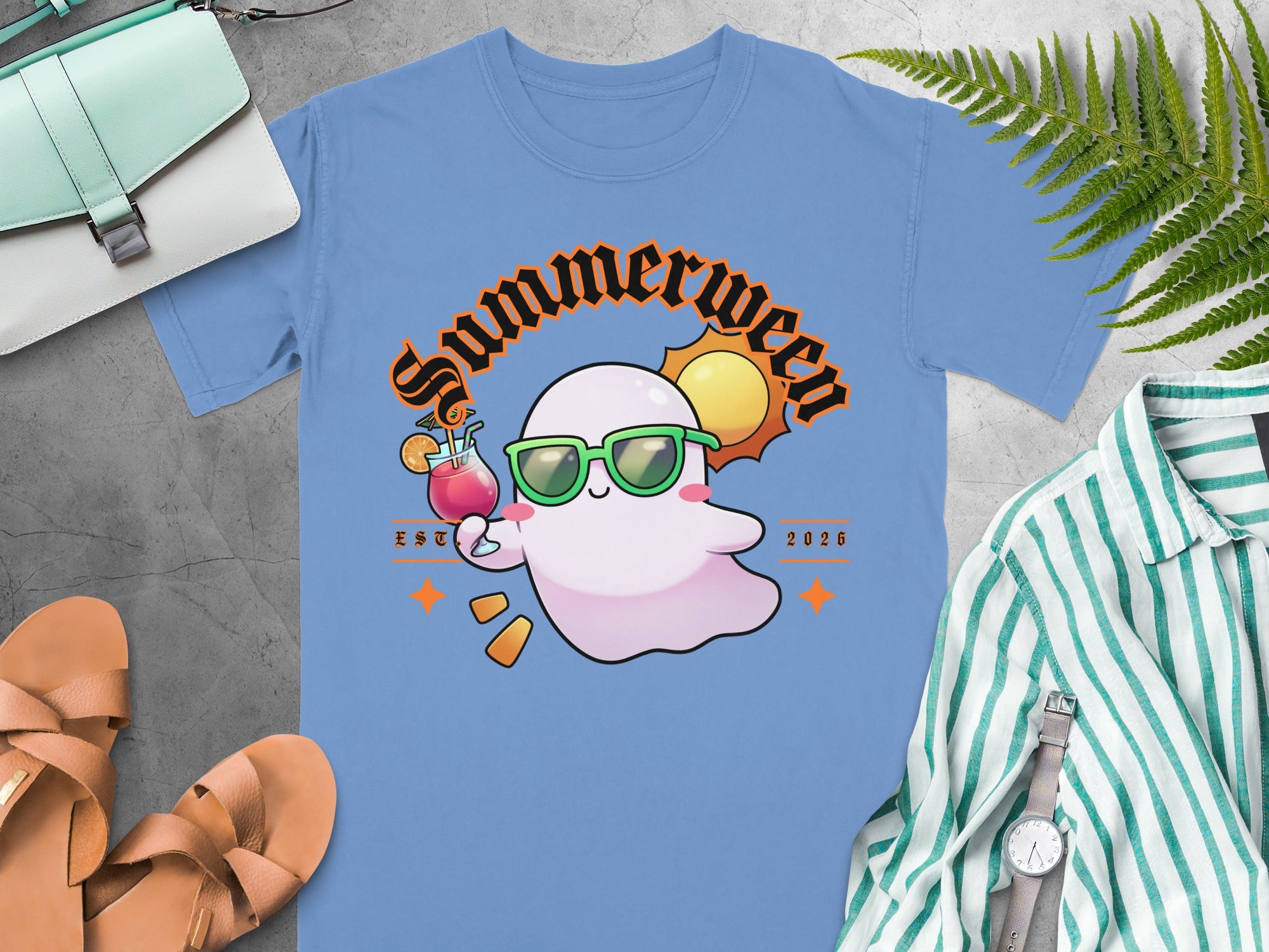 Light blue t-shirt with a ghost wearing sunglasses holding a cocktail and "Summerween EST 2026" text.