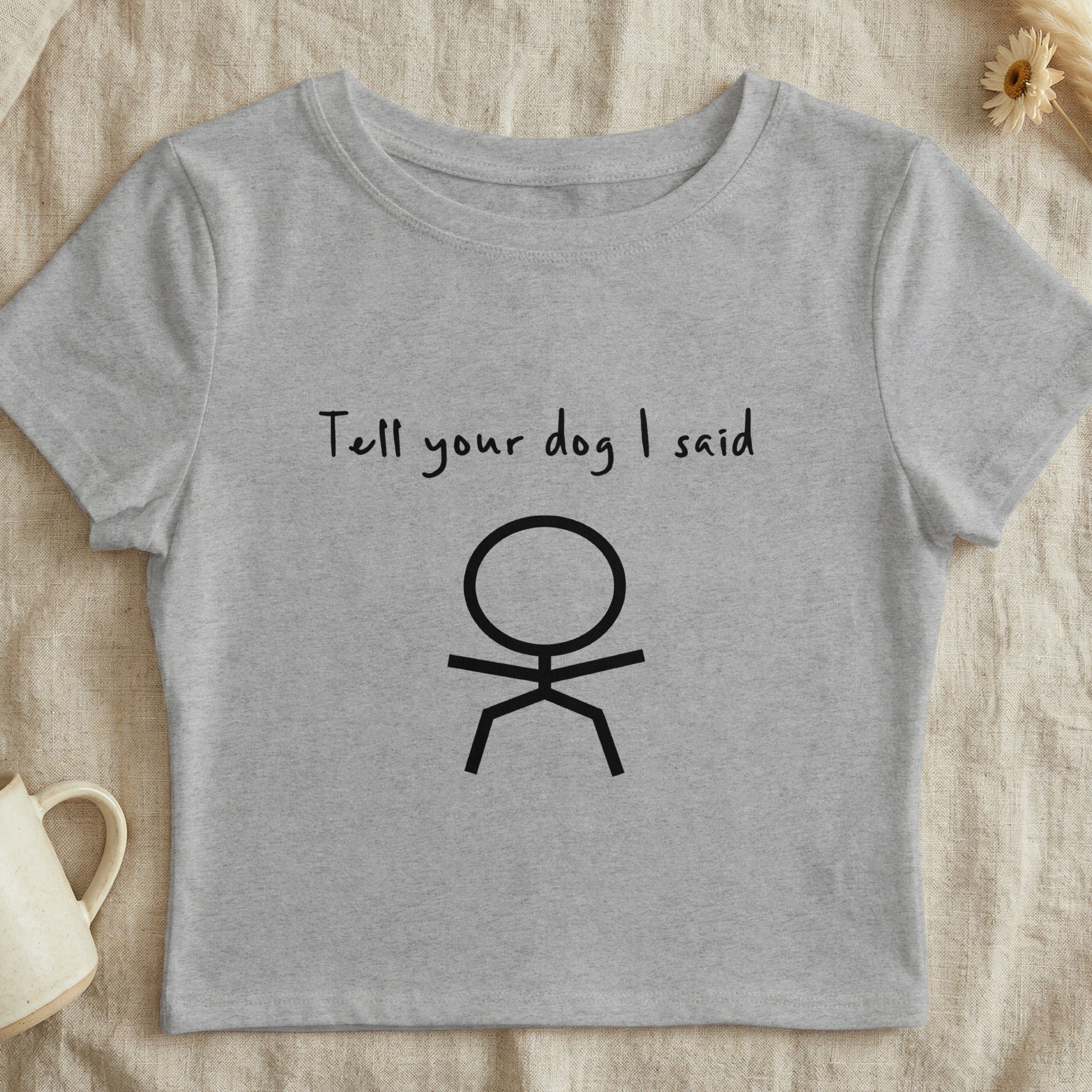 Grey cropped t-shirt with "Tell your dog I said" and a stick figure graphic.