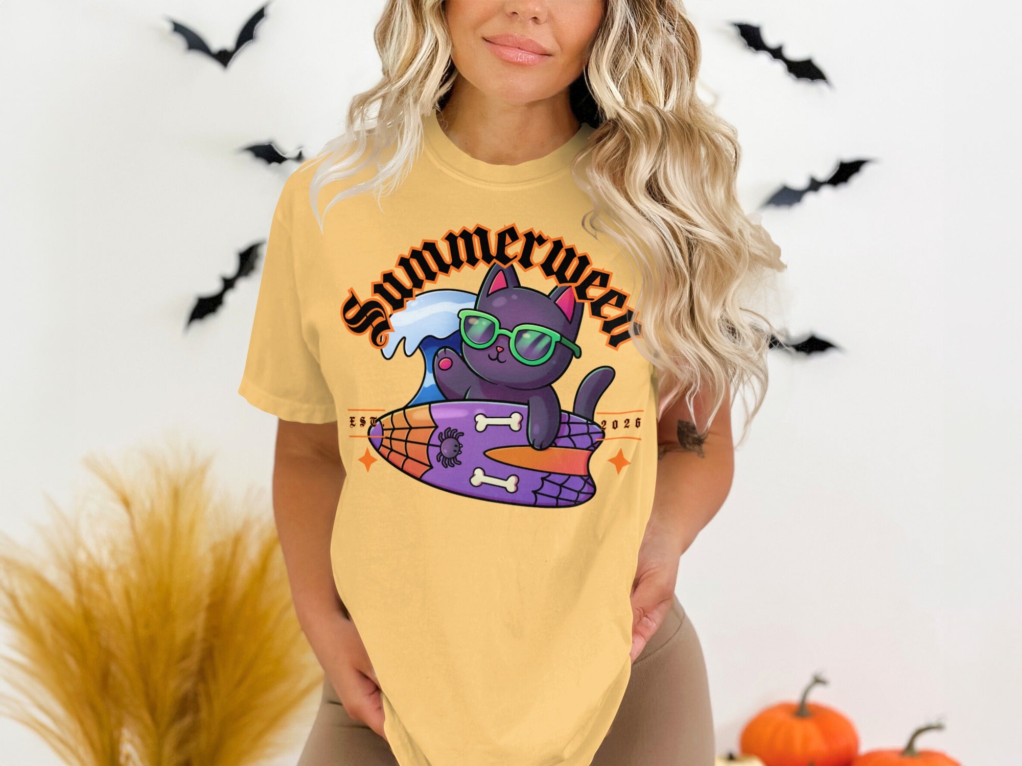 Yellow t-shirt with a graphic of a black cat surfing on a surfboard that says Summerween.