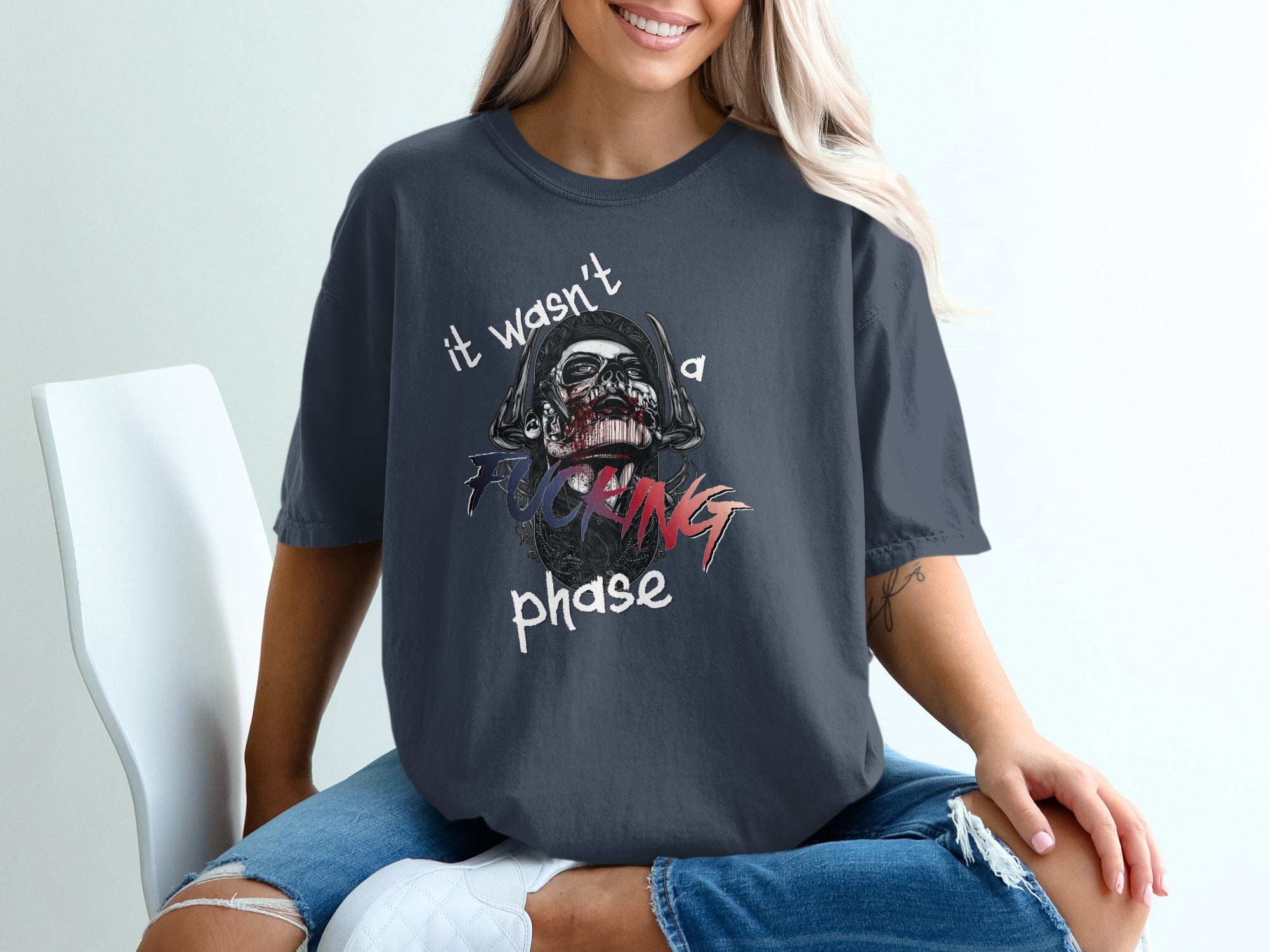Dark t-shirt with a skull graphic and "it wasn't a fucking phase" text.