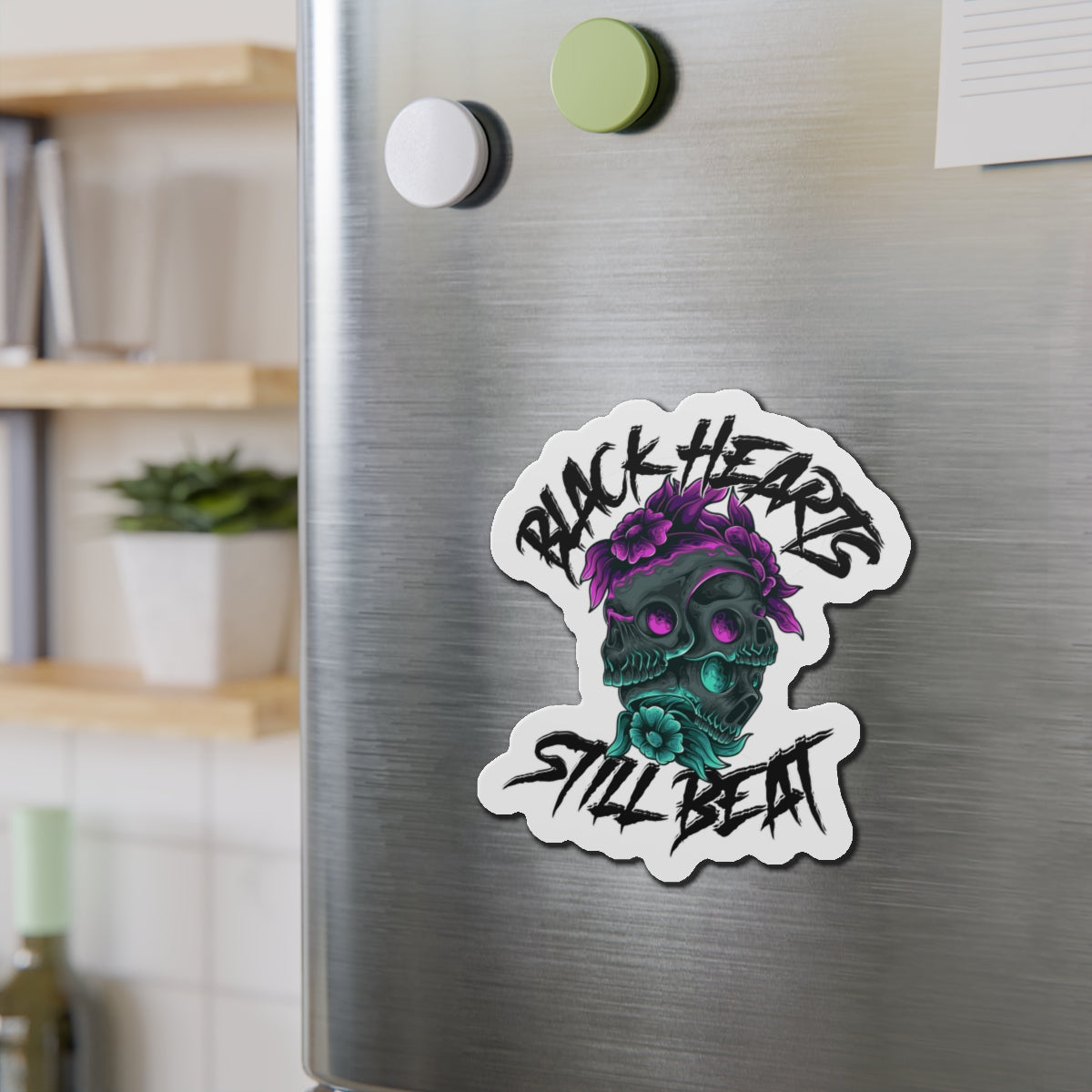 Sticker of a stylized skull with flowers and text "BLACK HEARTS STILL BEAT".