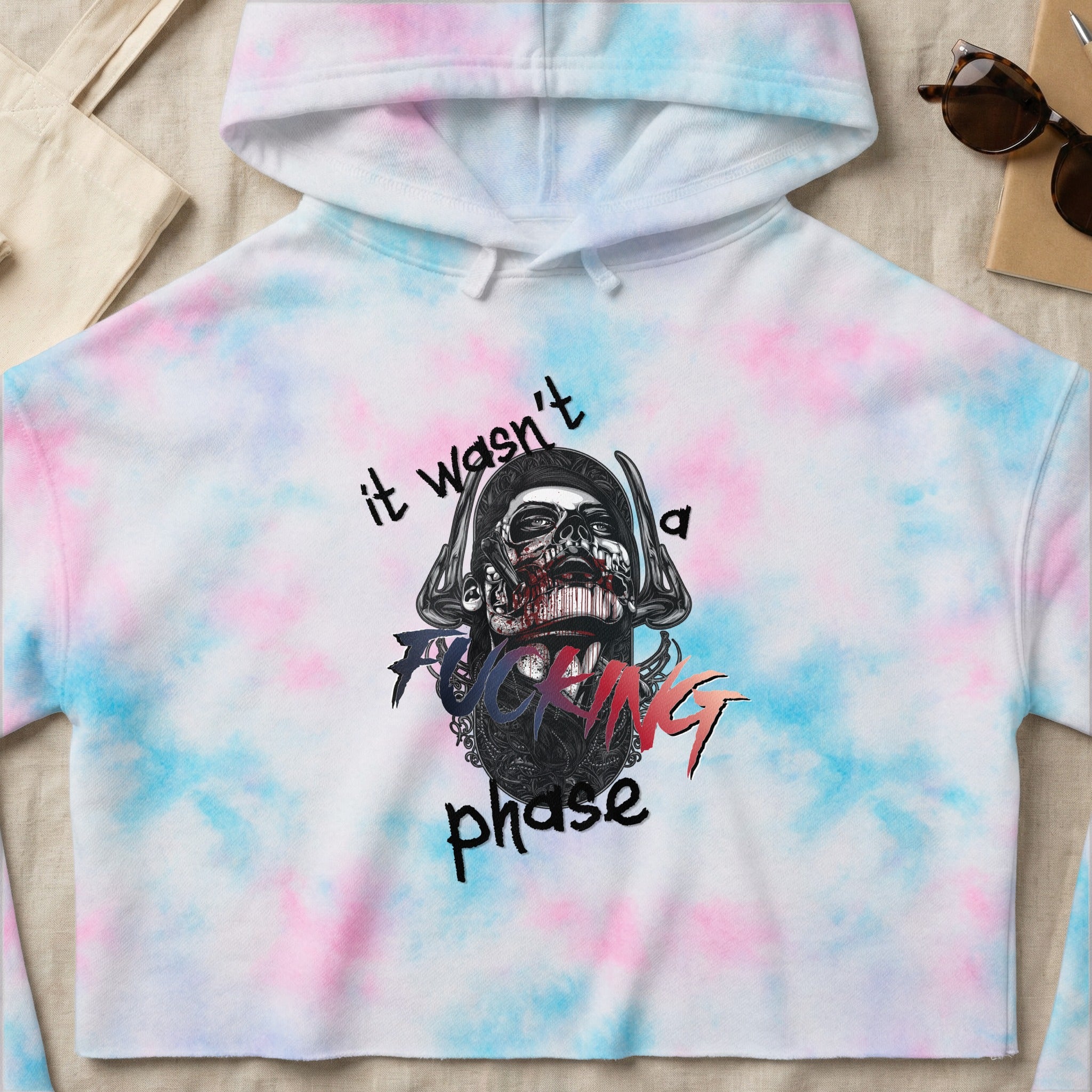 Tie-dye cropped hoodie with skull graphic and text "it wasn't a fucking phase".