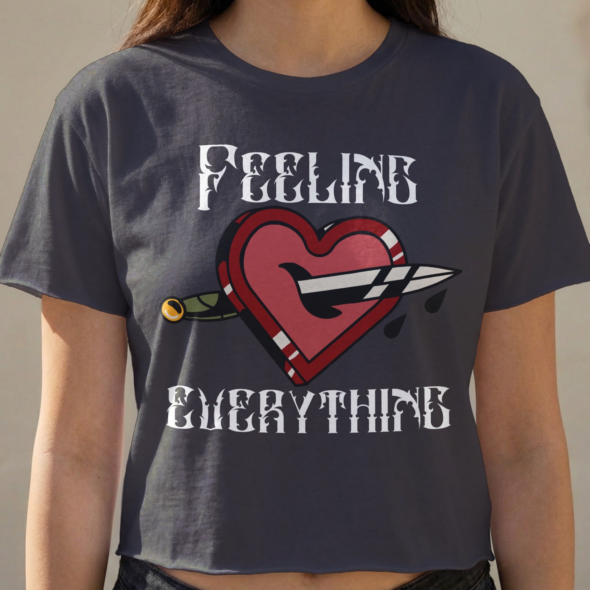 Dark t-shirt with "FEELING EVERYTHING" and a dagger through a heart graphic.