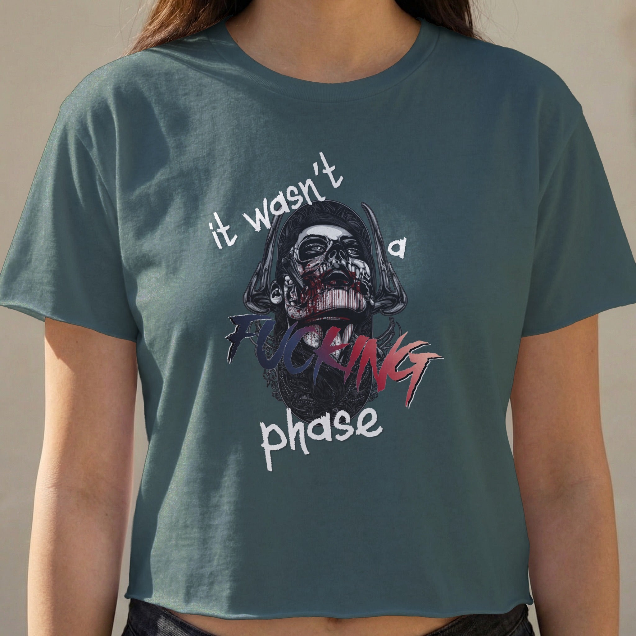 Dark teal crop top with skull graphic and "it wasn't a fucking phase" text.