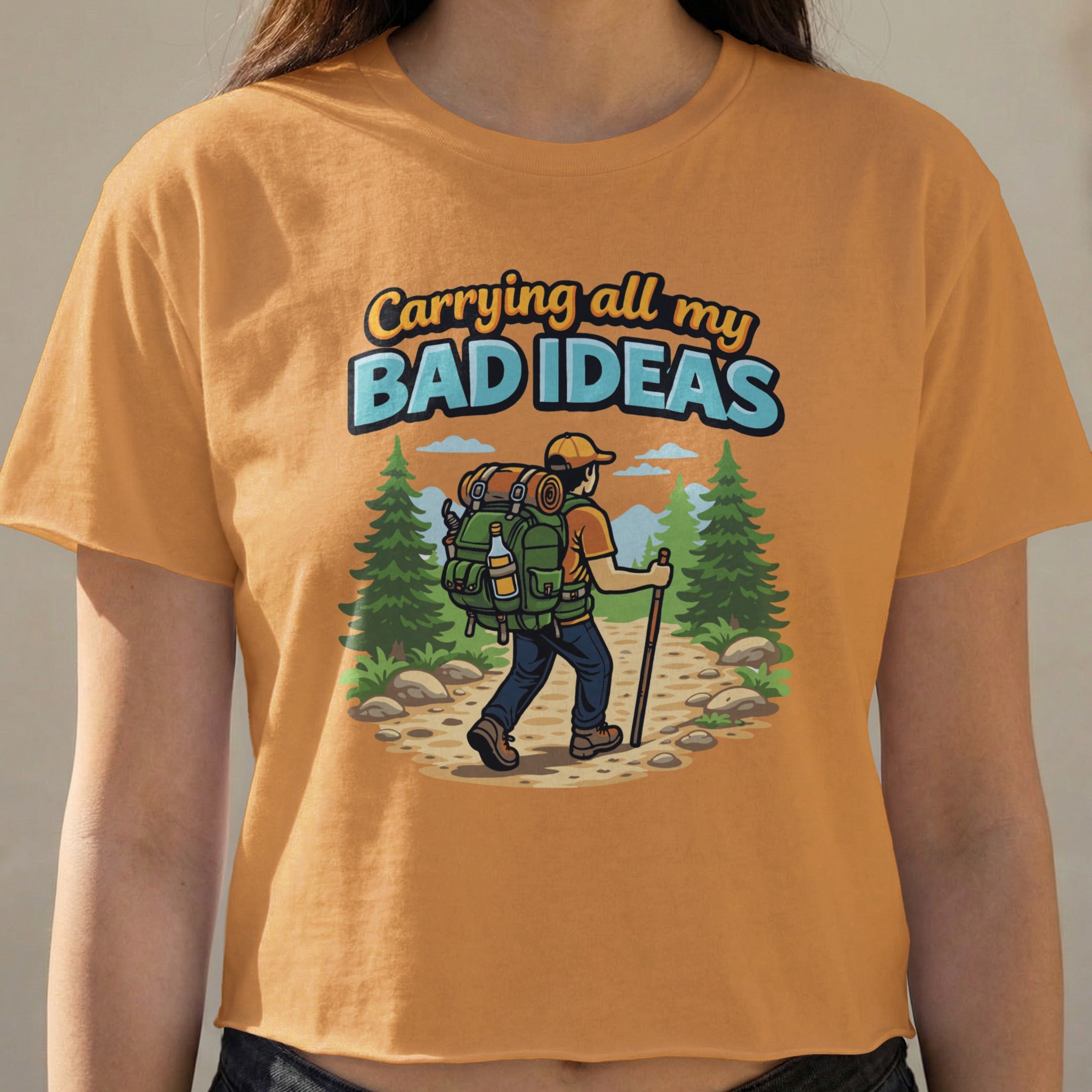 T-shirt with graphic of hiker carrying backpack and text "Carrying all my bad ideas."