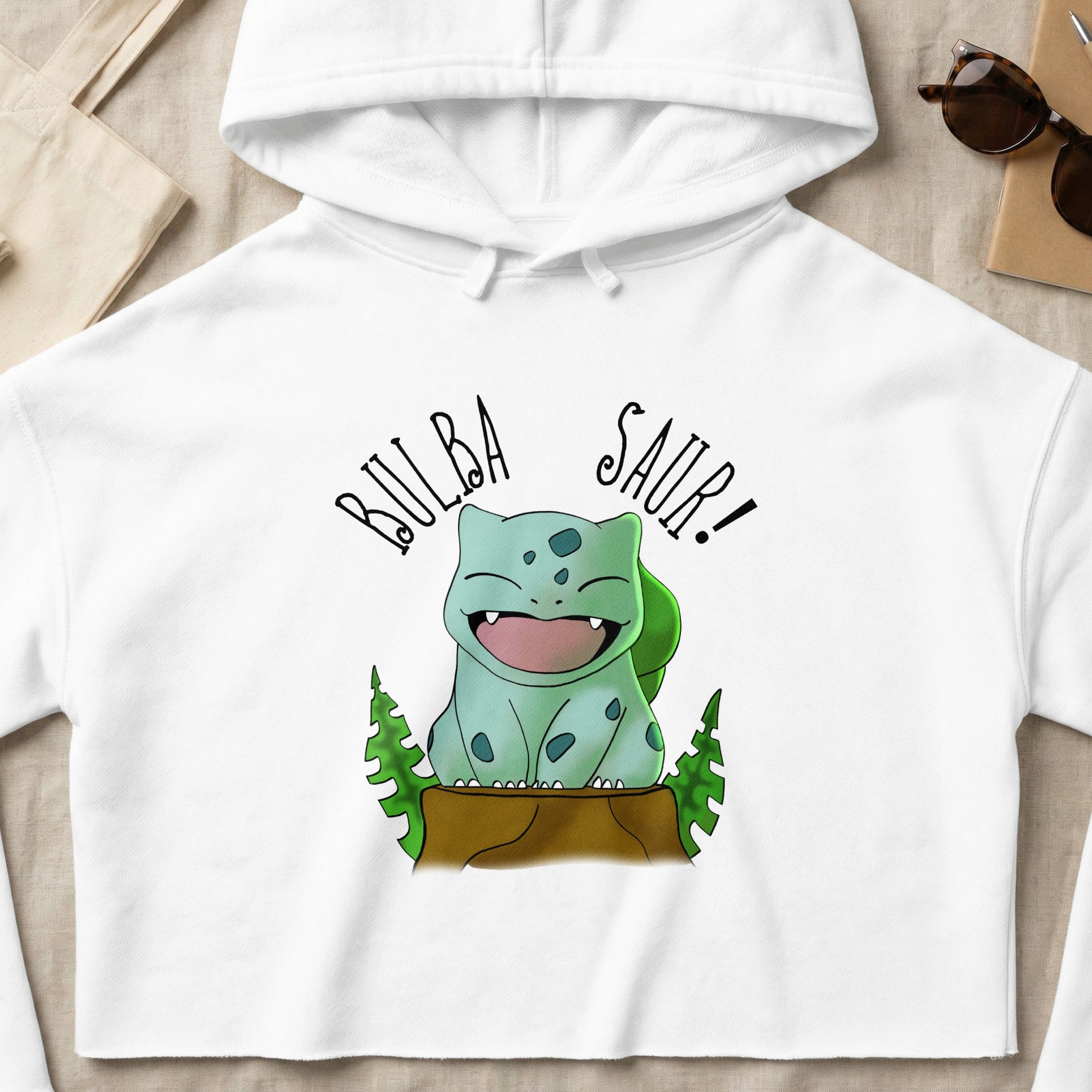 Bulbasaur character with "BULBASAUR!" text on a white cropped hoodie.