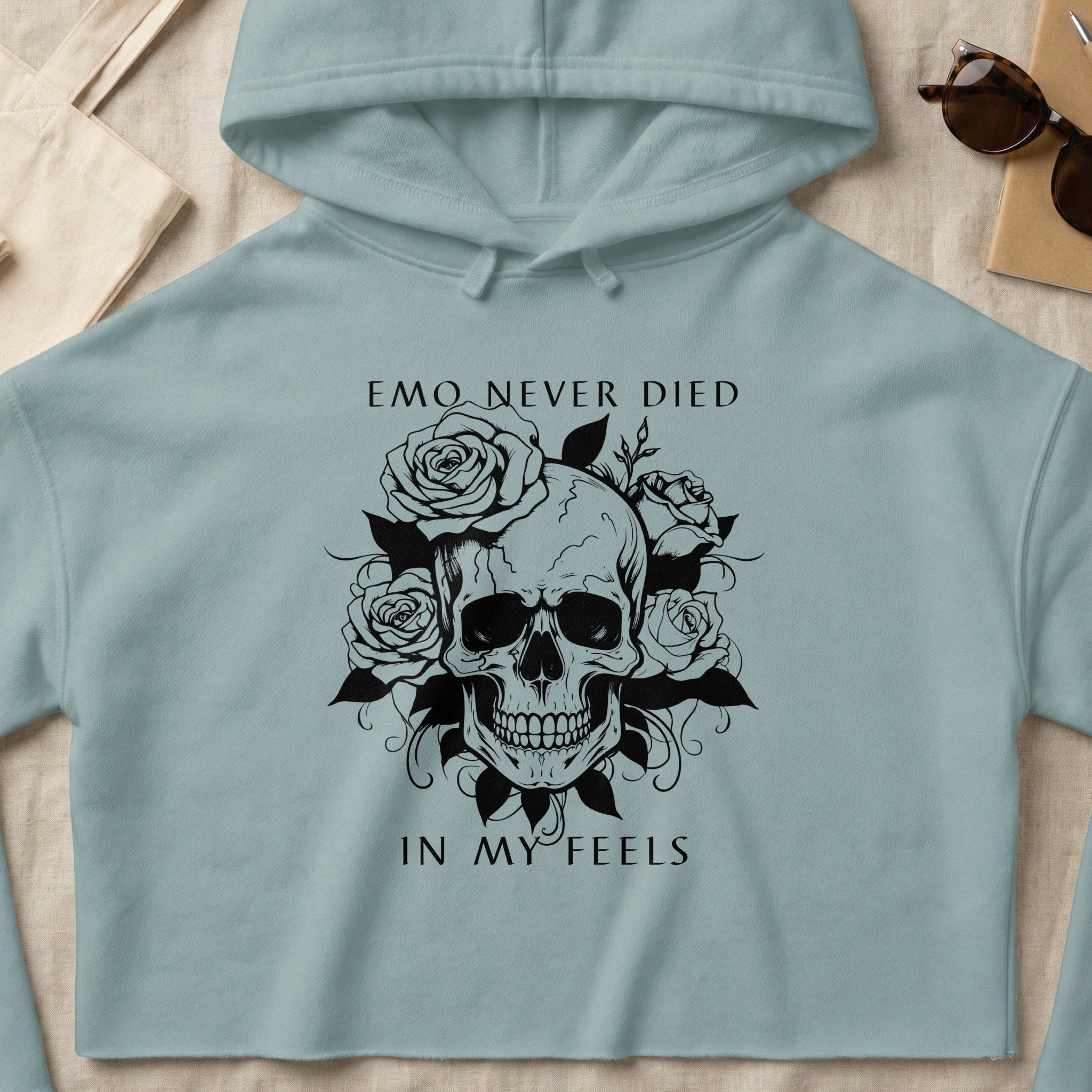 Black skull and roses graphic on light blue cropped hoodie.