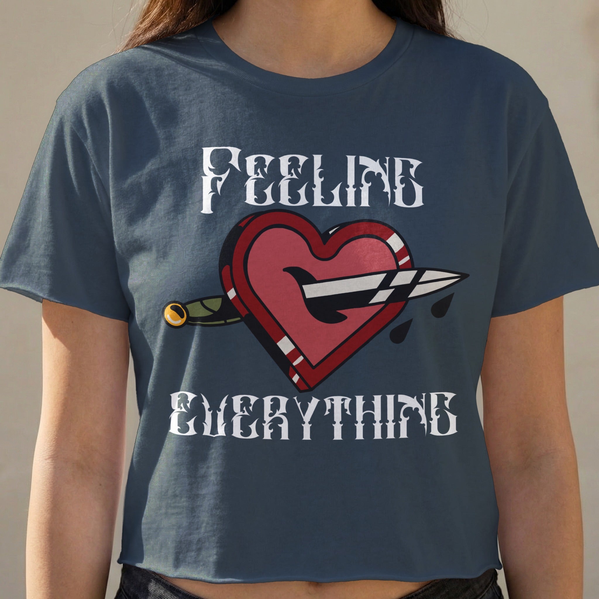 Navy crop top with a heart pierced by a dagger and text "FEELING EVERYTHING".