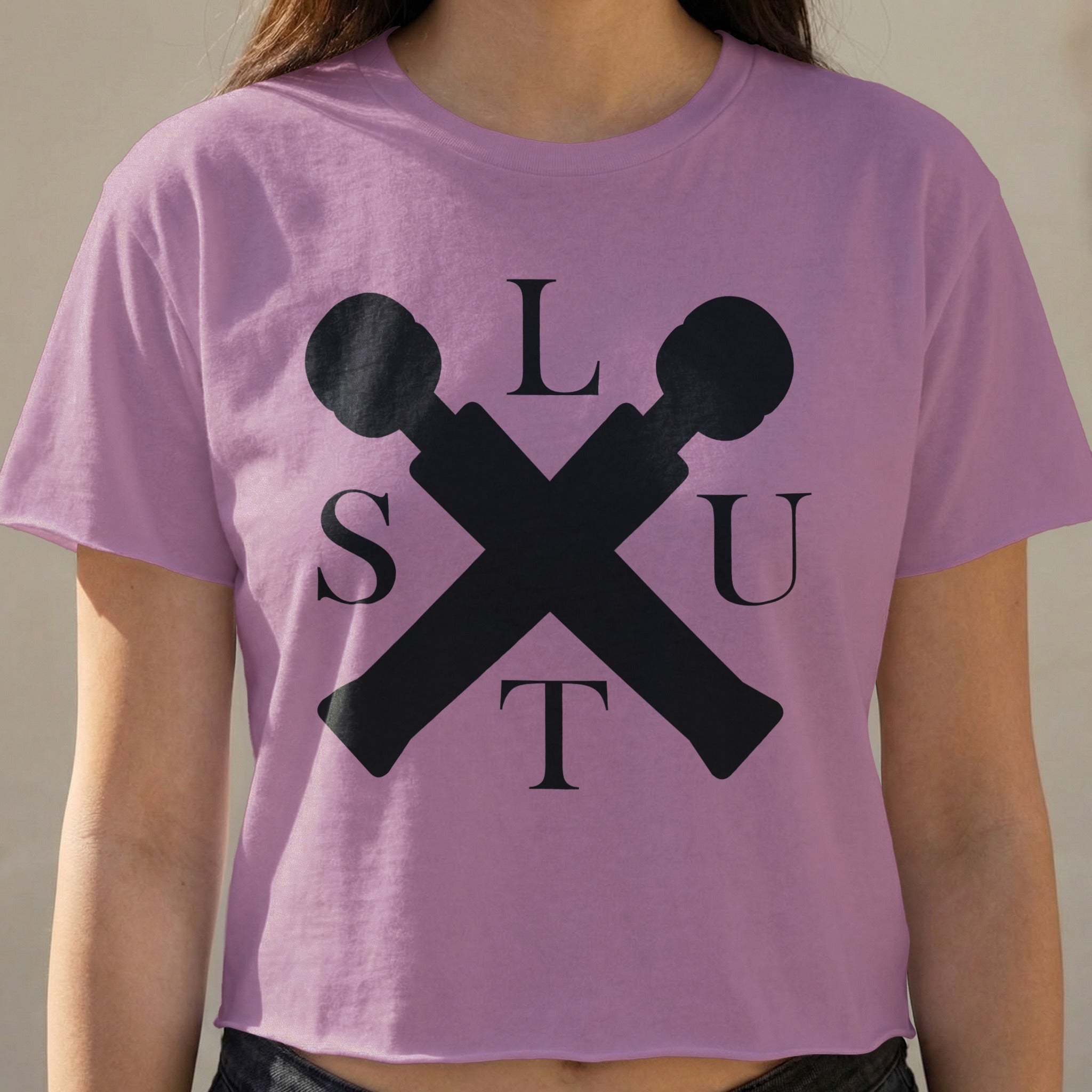 Pink t-shirt with black "SLUT" spelled out around crossed microphones.