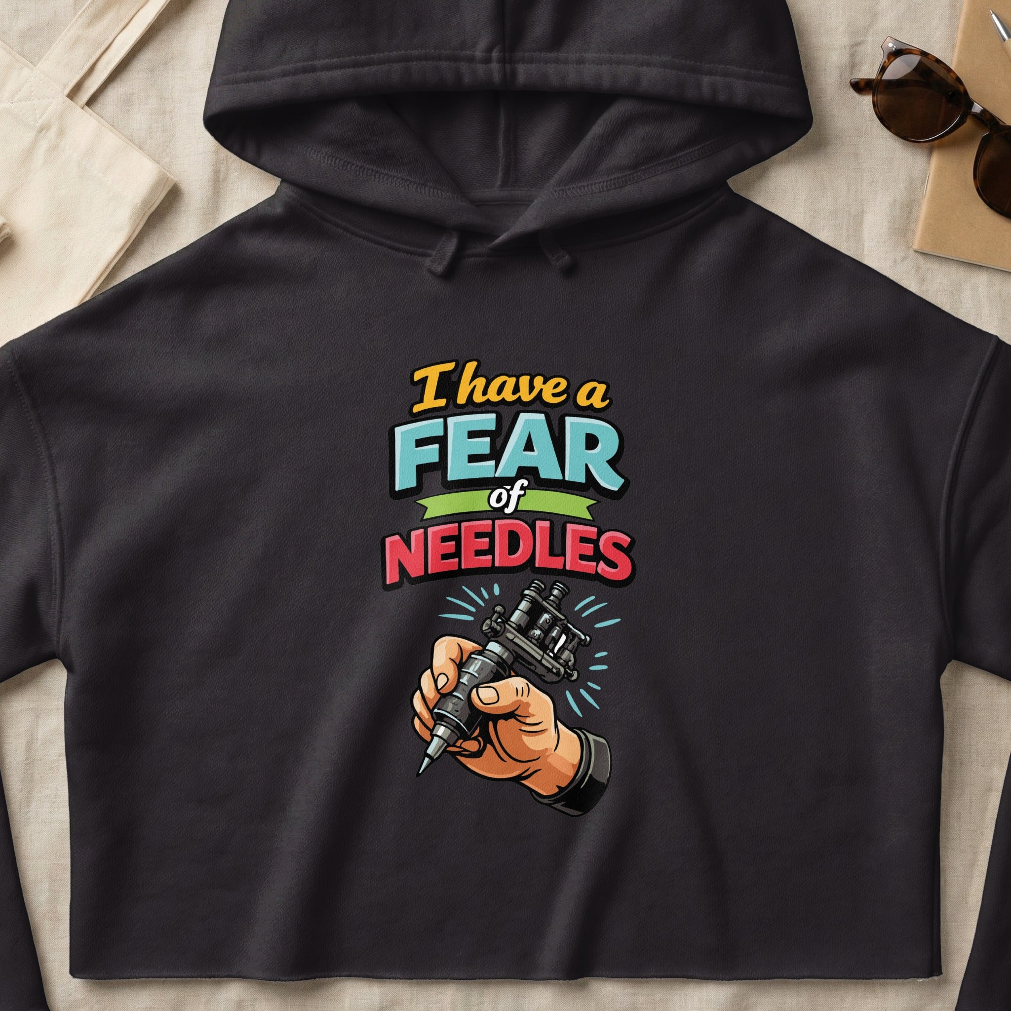 Black hoodie with a hand holding a tattoo gun and text "I have a fear of needles."