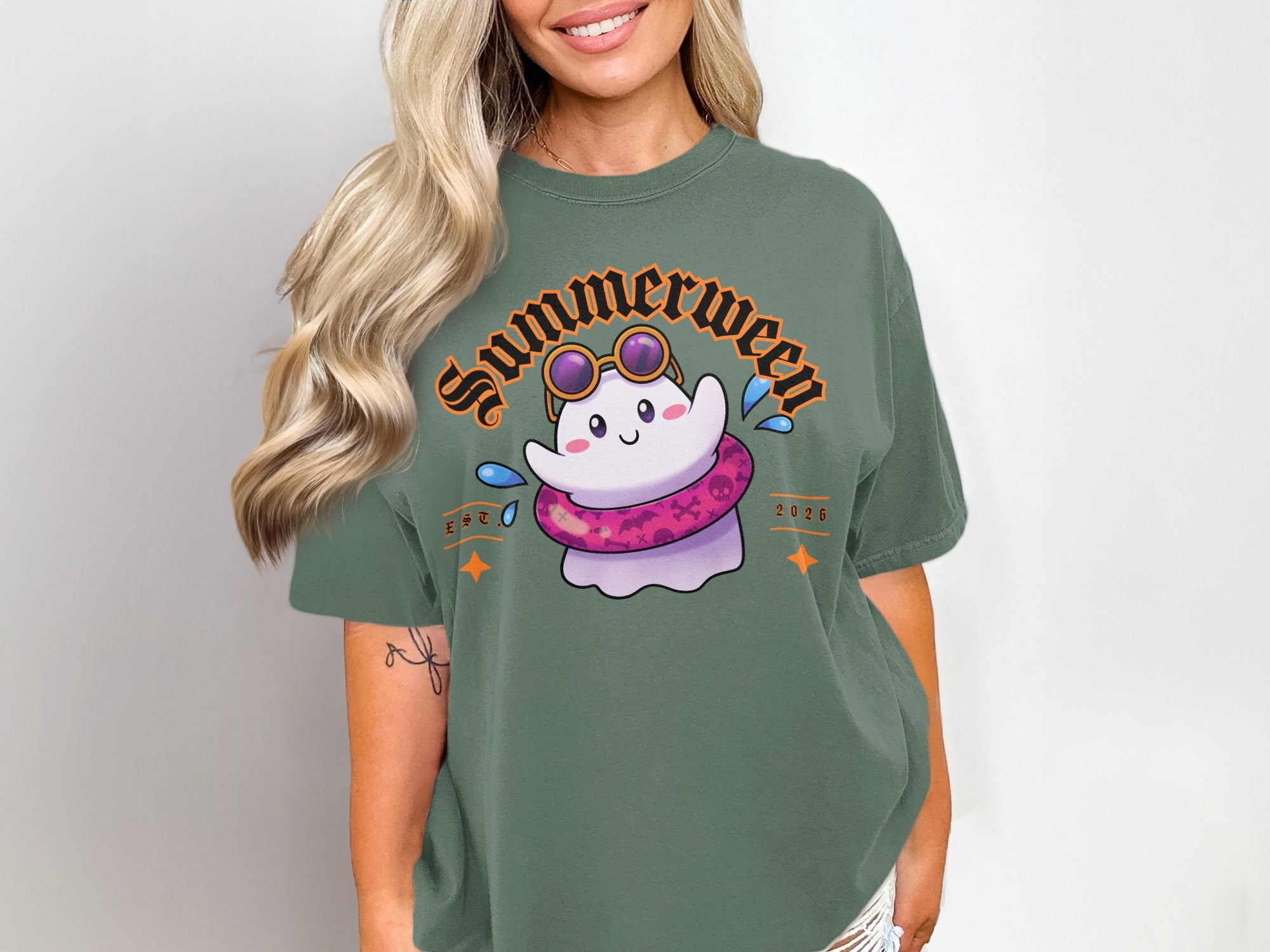Green t-shirt with a cute ghost wearing sunglasses and a pink inner tube.
