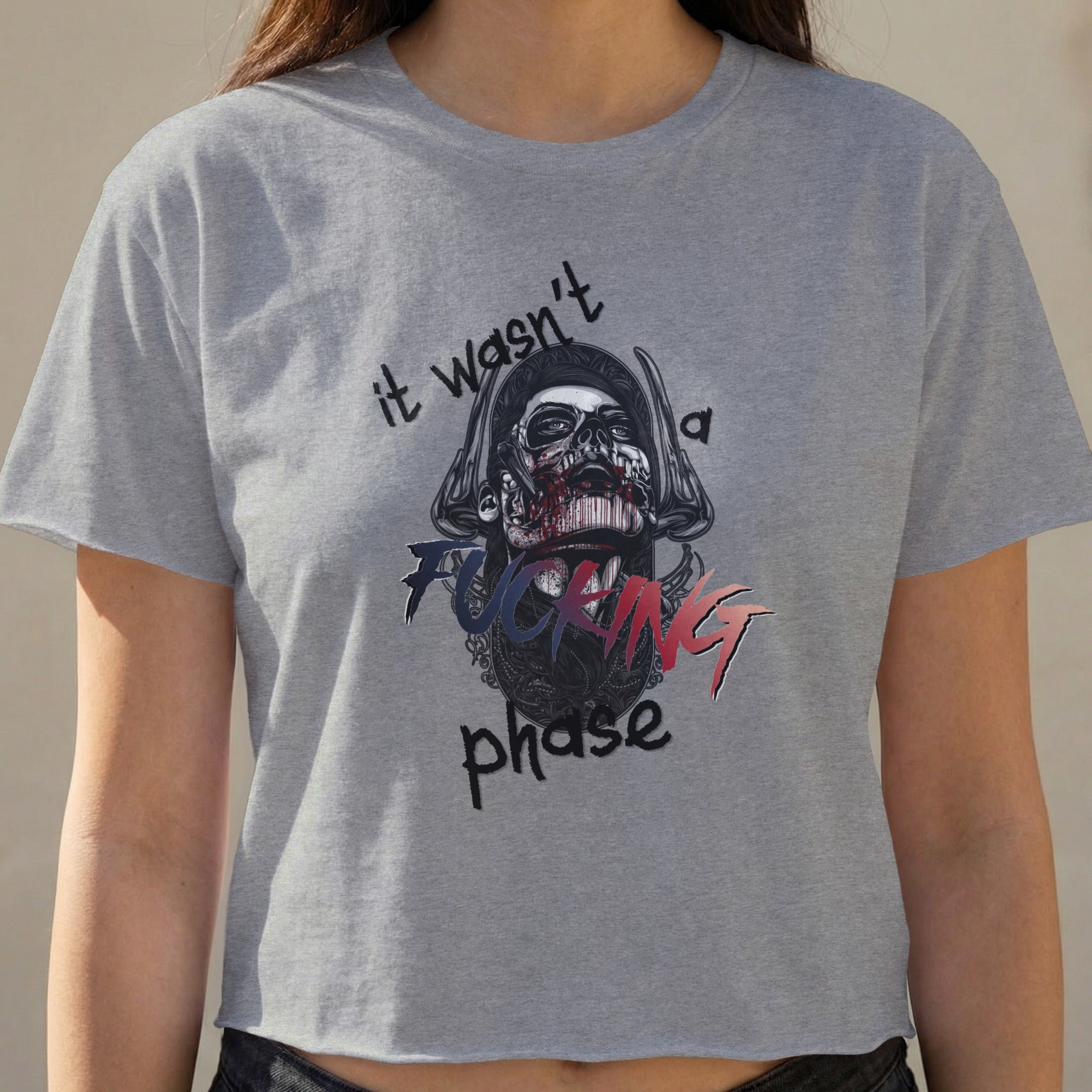 Gray cropped t-shirt with skull graphic and text "it wasn't a fucking phase".