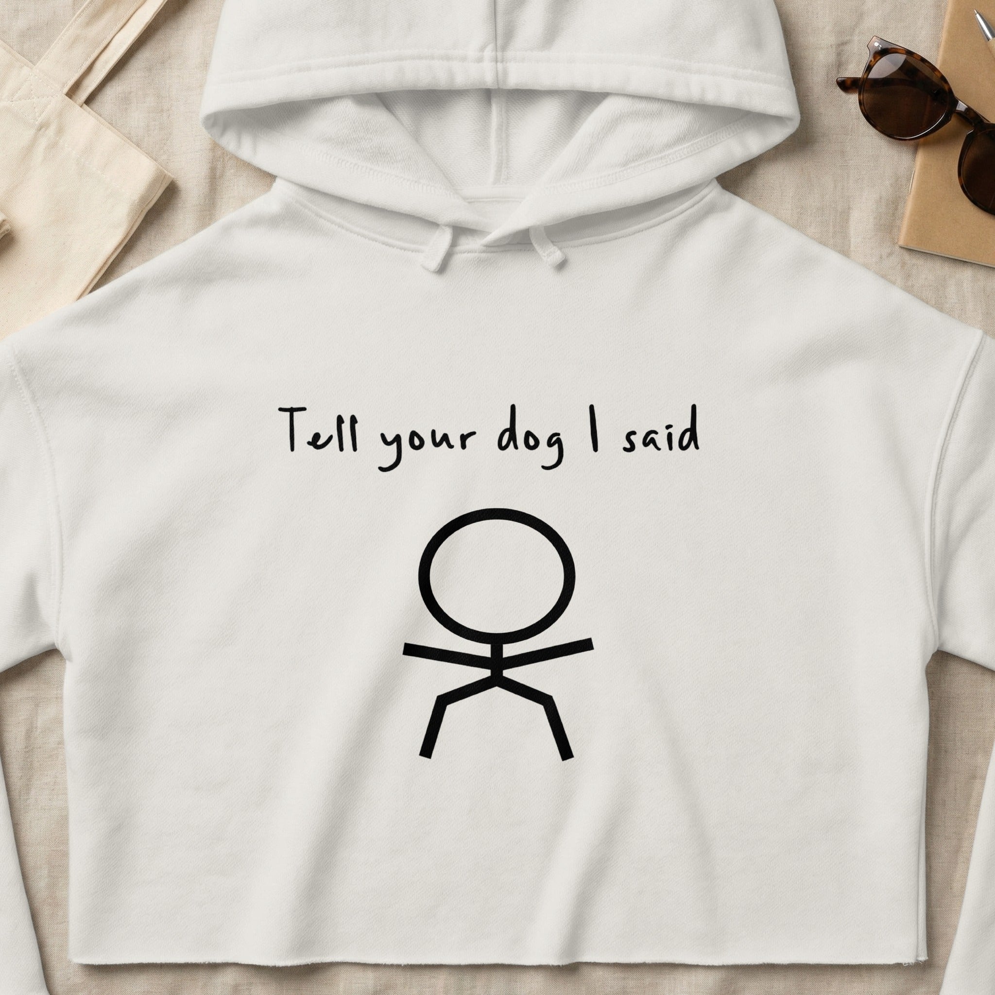 White cropped hoodie with "Tell your dog I said" text and stick figure.