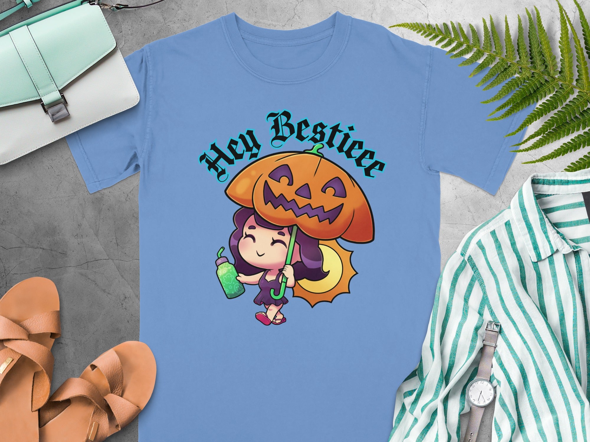 Blue t-shirt with a cartoon girl holding a pumpkin umbrella and "Hey Bestieee" text.