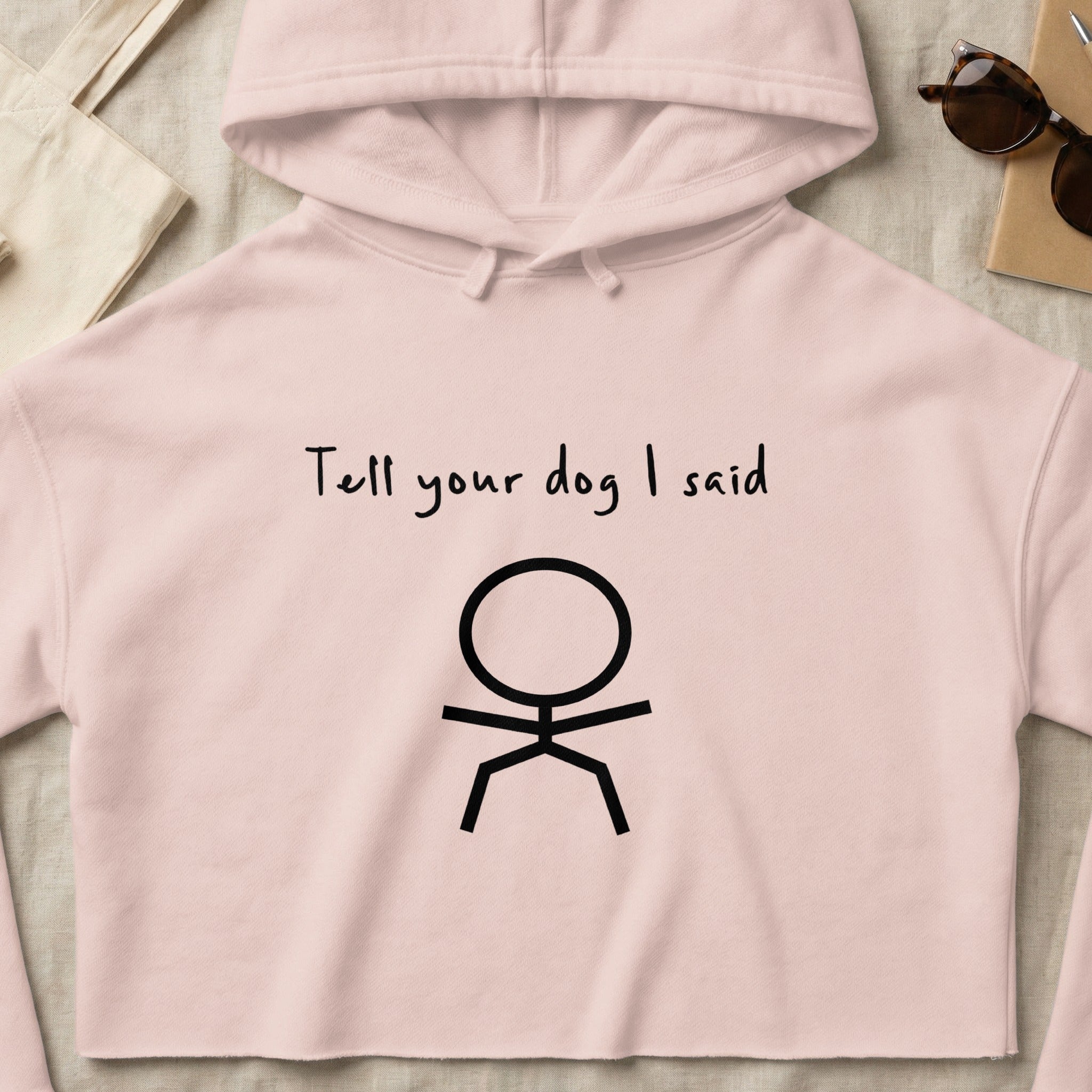 Pink cropped hoodie with "Tell your dog I said" and a stick figure.
