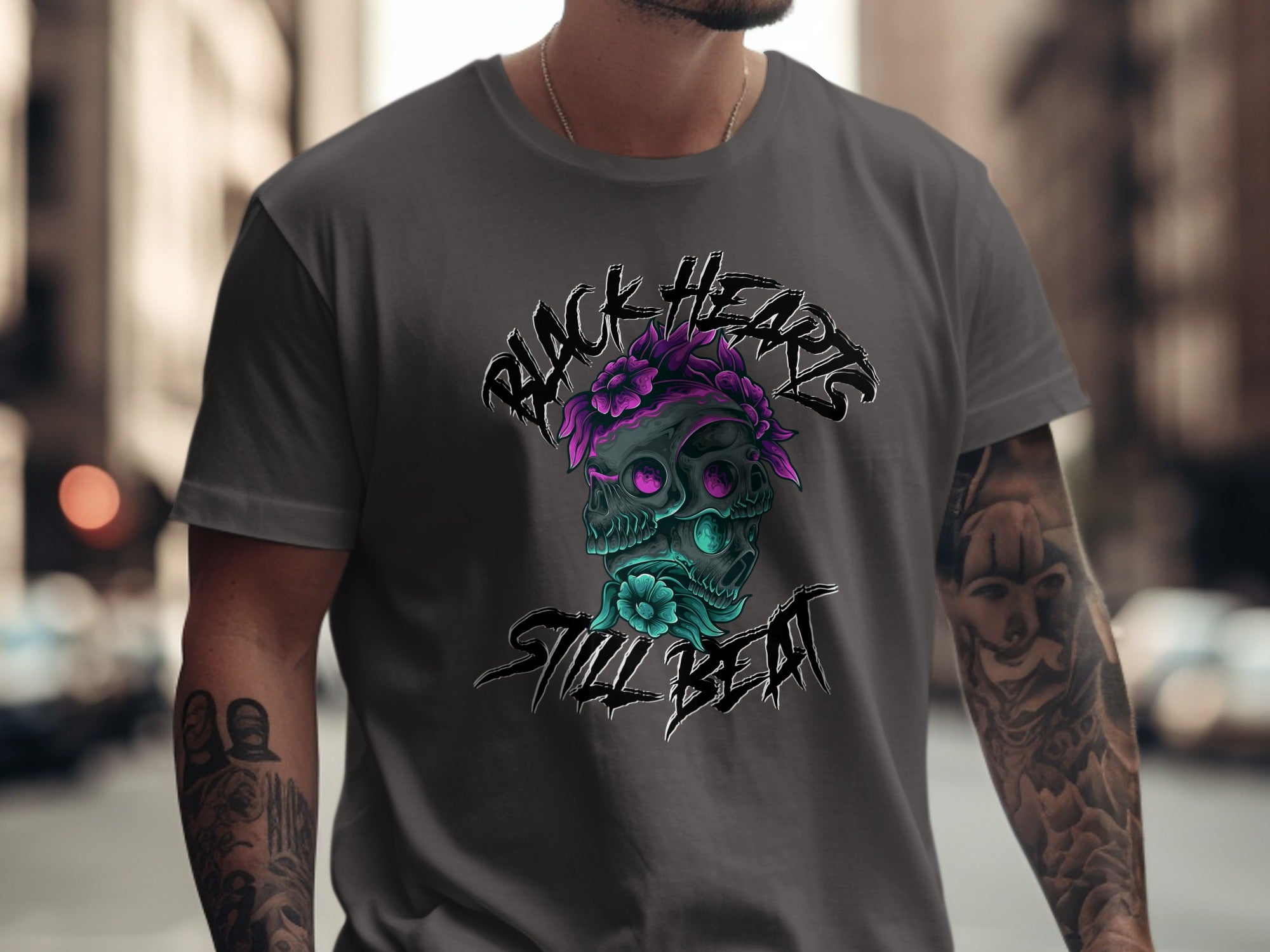 Skull with flowers and text "Black Hearts Still Beat" on a grey t-shirt.