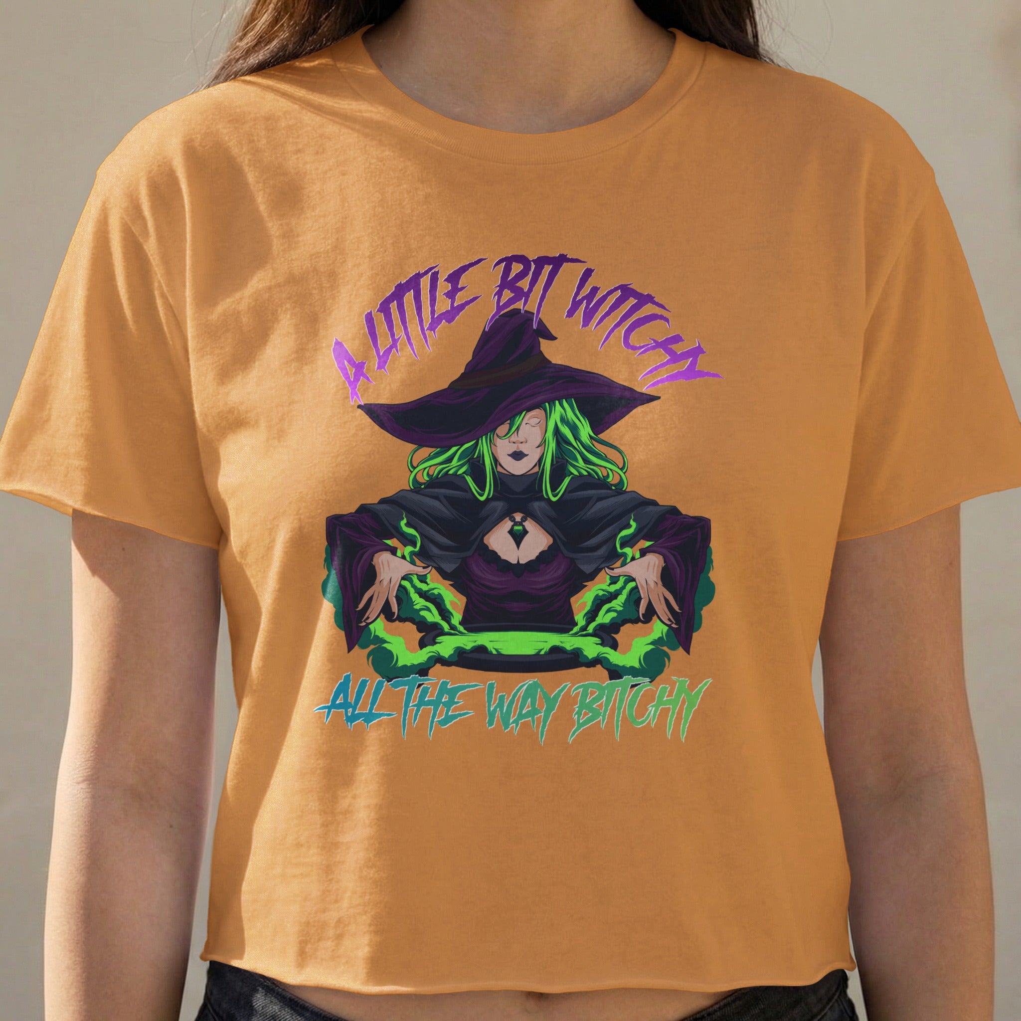 Woman wearing orange t-shirt with purple "A little bit witchy" and green "all the way bitchy" text.