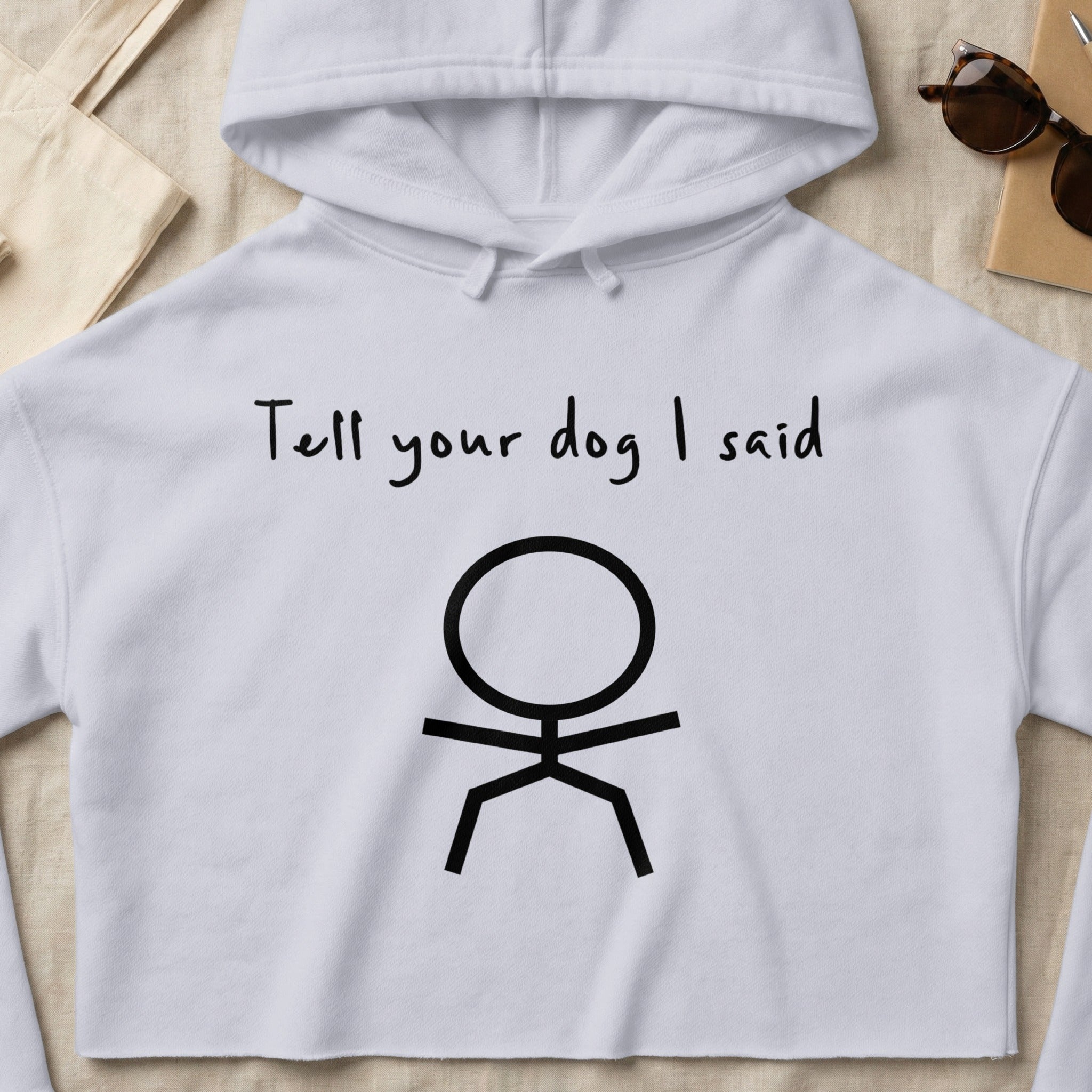 White cropped hoodie with stick figure and text "Tell your dog I said".