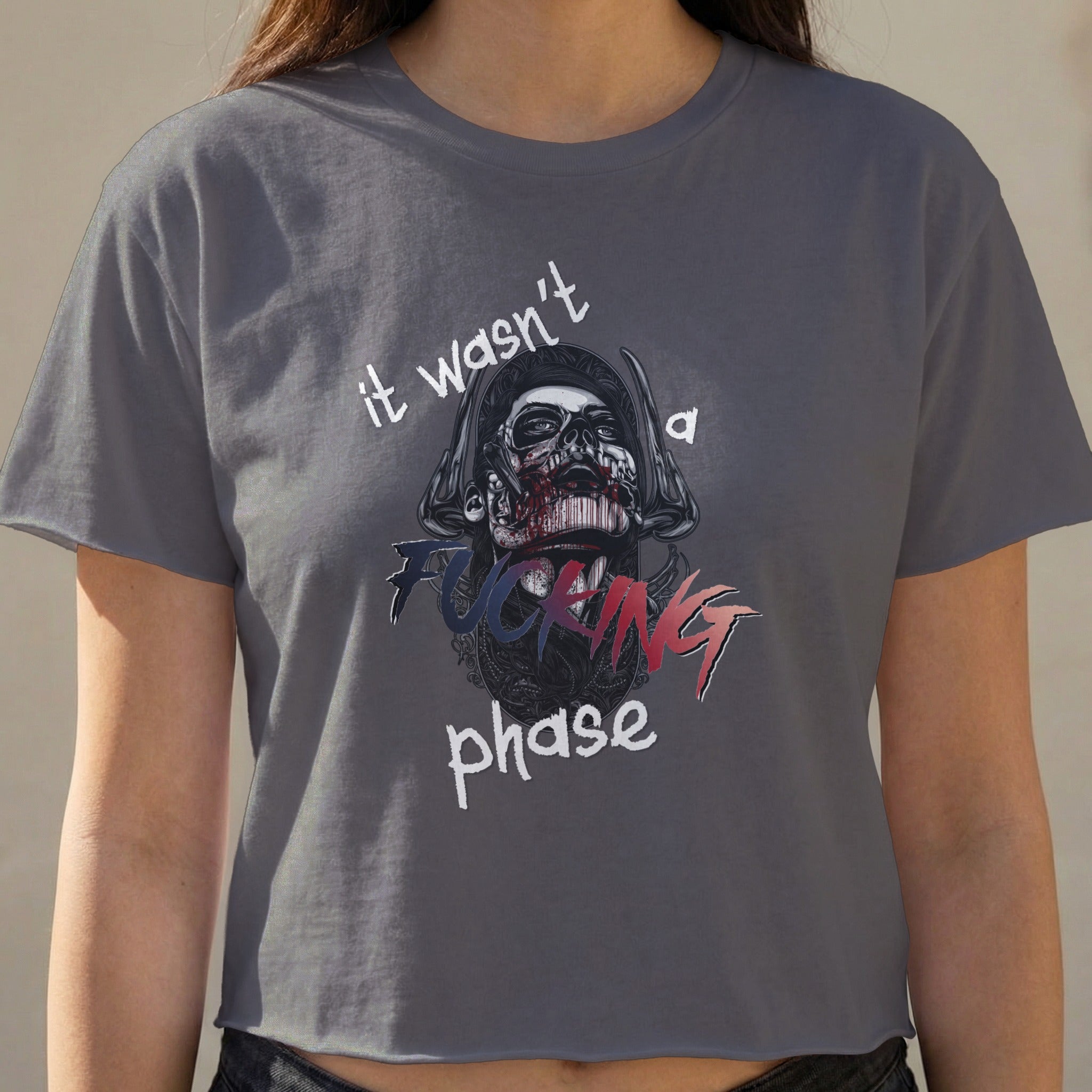 Dark grey cropped t-shirt with skull graphic and "it wasn't a FUCKING phase" text.
