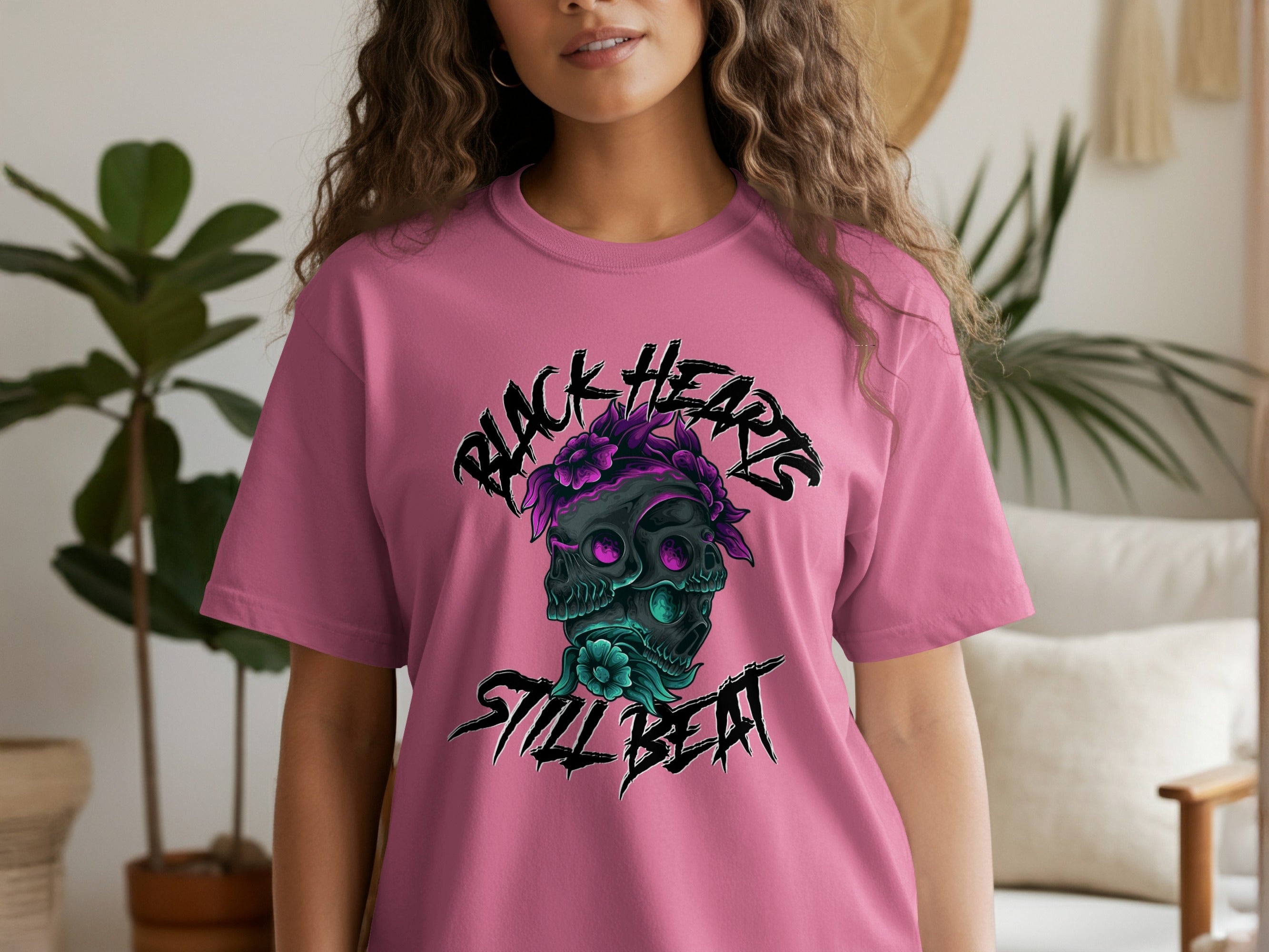 Pink t-shirt with black floral skull design and "BLACK HEARTS STILL BEAT" text.